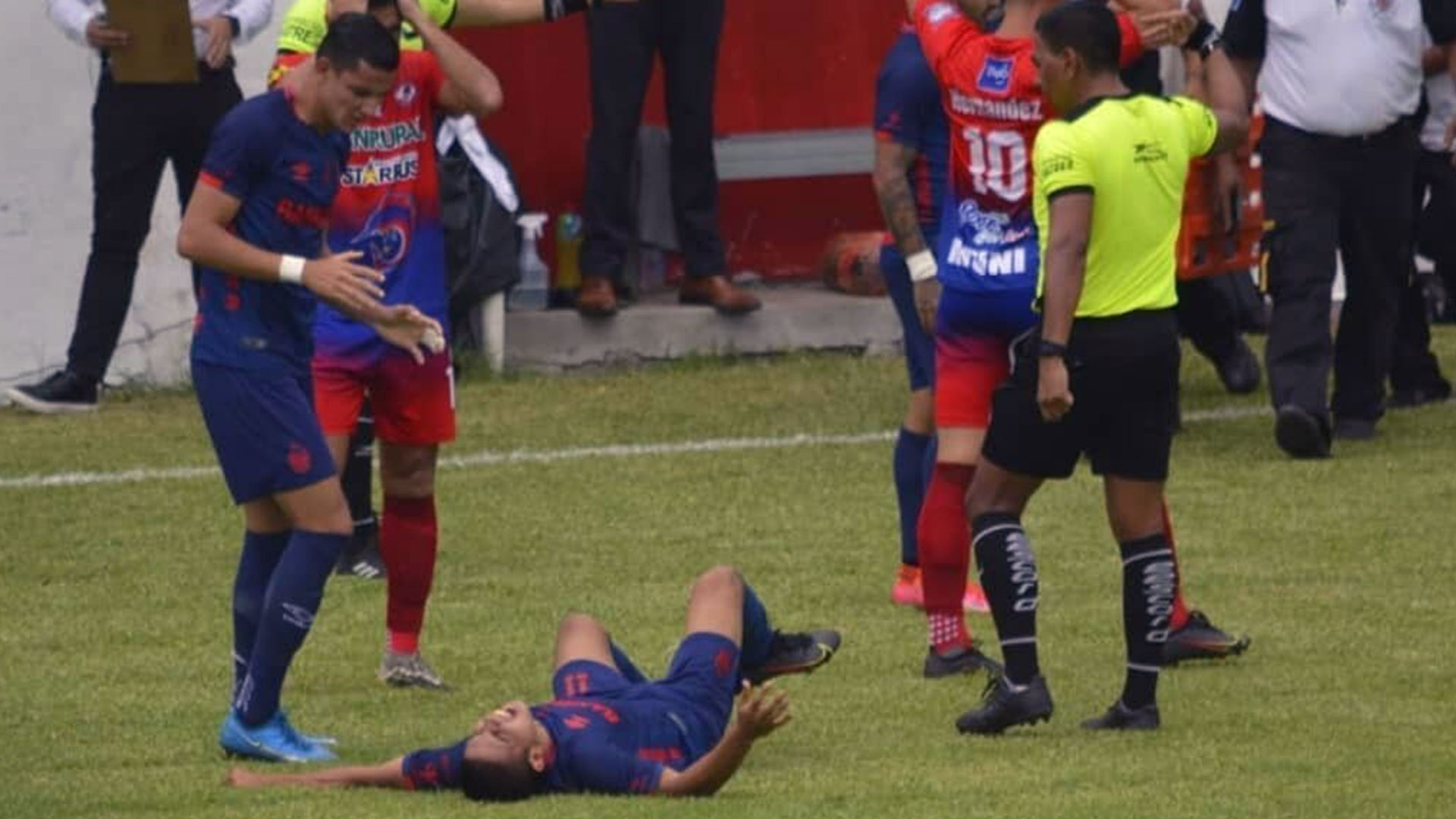 John Méndez después de lesionarse al minuto 2' del partido contra Iztapa. Su compañero en Municipal Jose Carlos Martínez lo obserba con preocupación. (Foto Prensa Libre: FutbolerosGT)