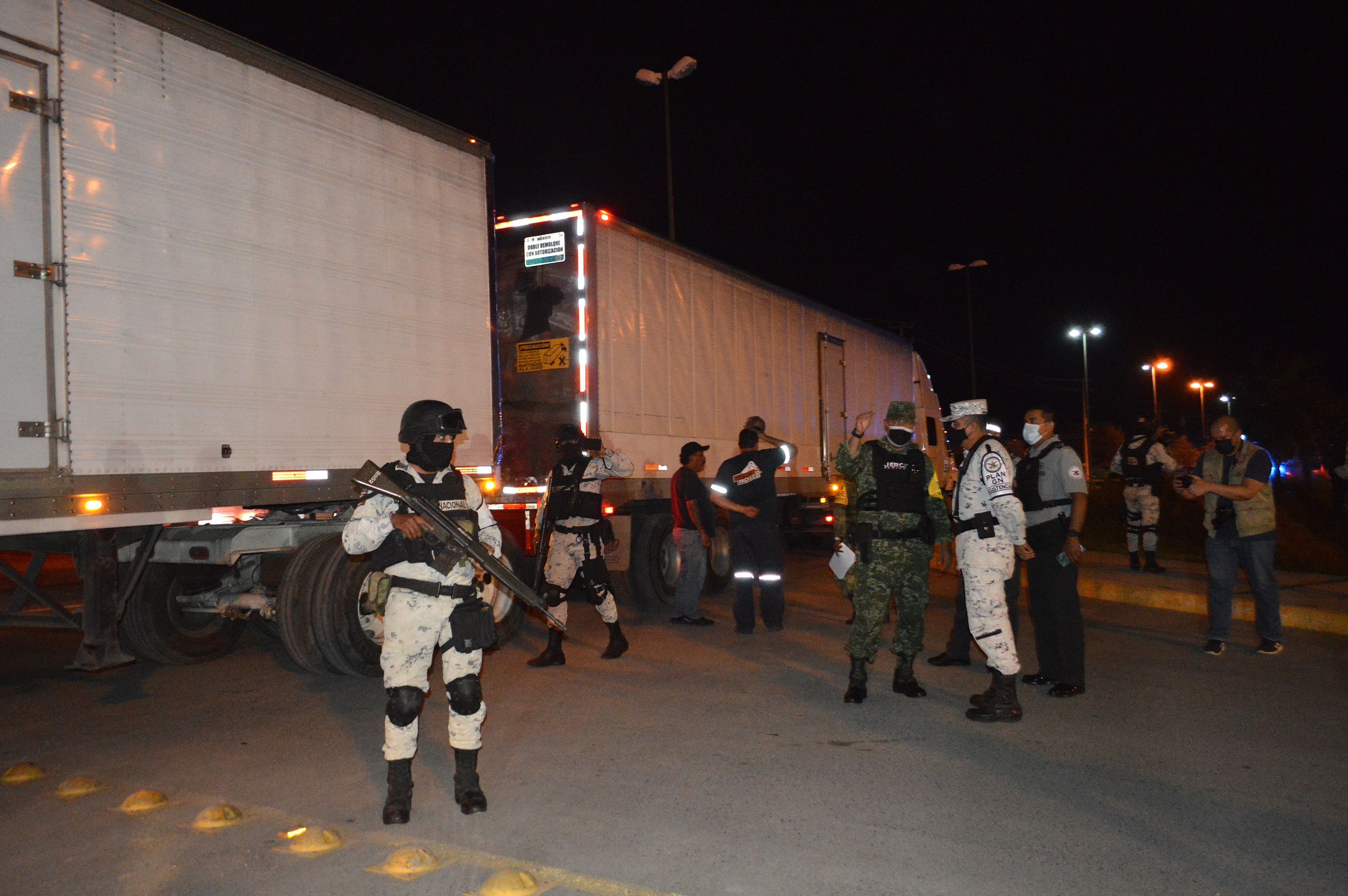 Miembros de la Guardia Nacional y de la Defensa Nacional custodian tres camiones que viajan con migrantes centroamericanos en el municipio de Hidalgo, Tamaulipas, México. (Foto Prensa Libre: EFE)