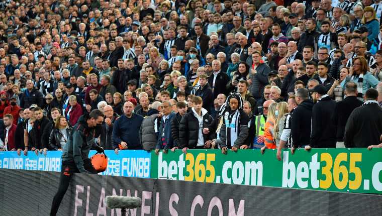 El momento exacto en el que un miembro del staff médico se dispuso a prestar asistencia a un espectador del duelo entre Newcastle United y Tottenham Hotspur. (Foto Prensa Libre: EFE)