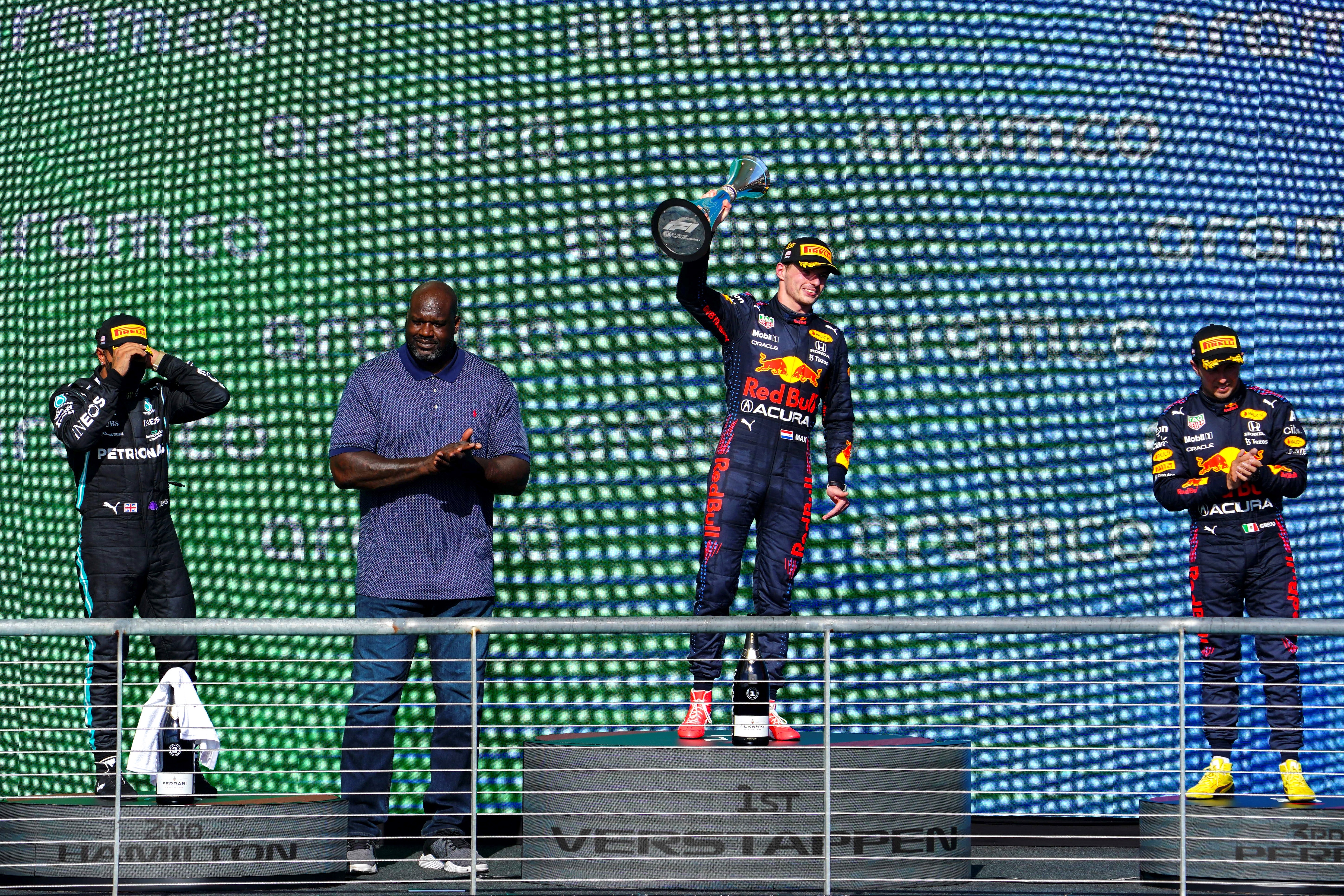 El piloto neerlandés de F1 Max Verstappen de Red Bull Racing, junto al británico Lewis Hamilton (izquierda) de Mercedes-AMG Petronas, el mexicano Sergio Perez (derecha) de Red Bull Racing y el exjugador de la NBA, Shaquille O'Neal durante la premiación del Formula One Grand Prix de los Estados Unidos. (Foto Prensa Libre: EFE)