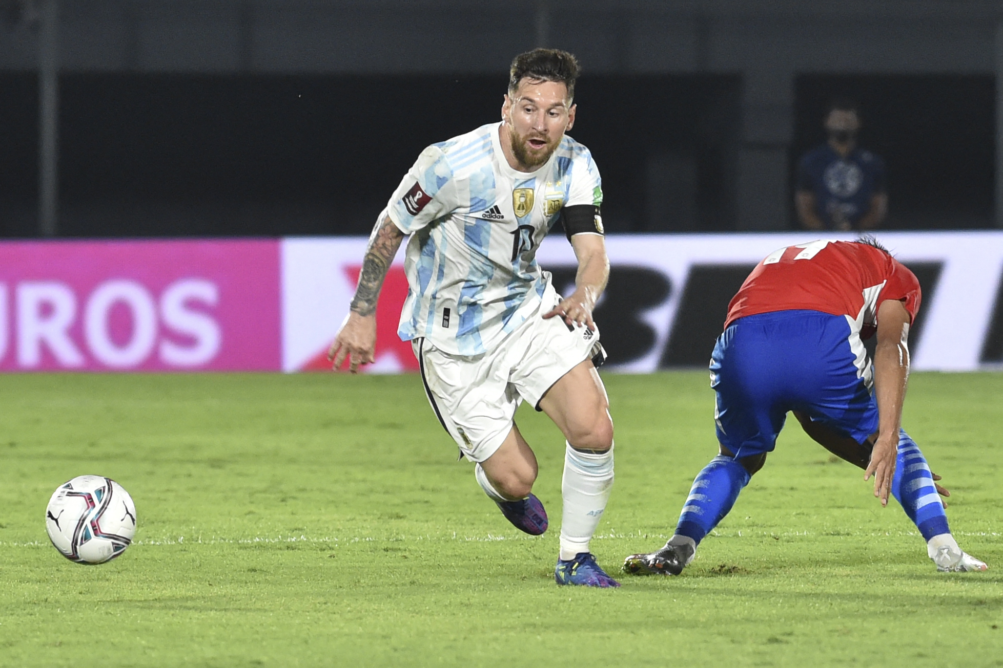 Lionel Messi y Santiago Arzamendia disputan un balón en el juego eliminatorio para Qatar 2022 que disputaron en el estadio Defensores del Chaco en Asunción. Foto Prensa Libre: AFP.