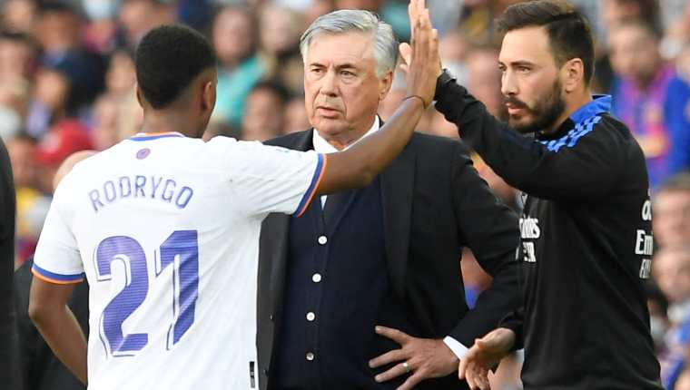 El entrenador del Real Madrid Carlo Ancelotti (Centro) platica con Rodrygo reemplazado en el duelo ante el FC Barcelona el fin de semana anterior. (Foto Prensa Libre: AFP)