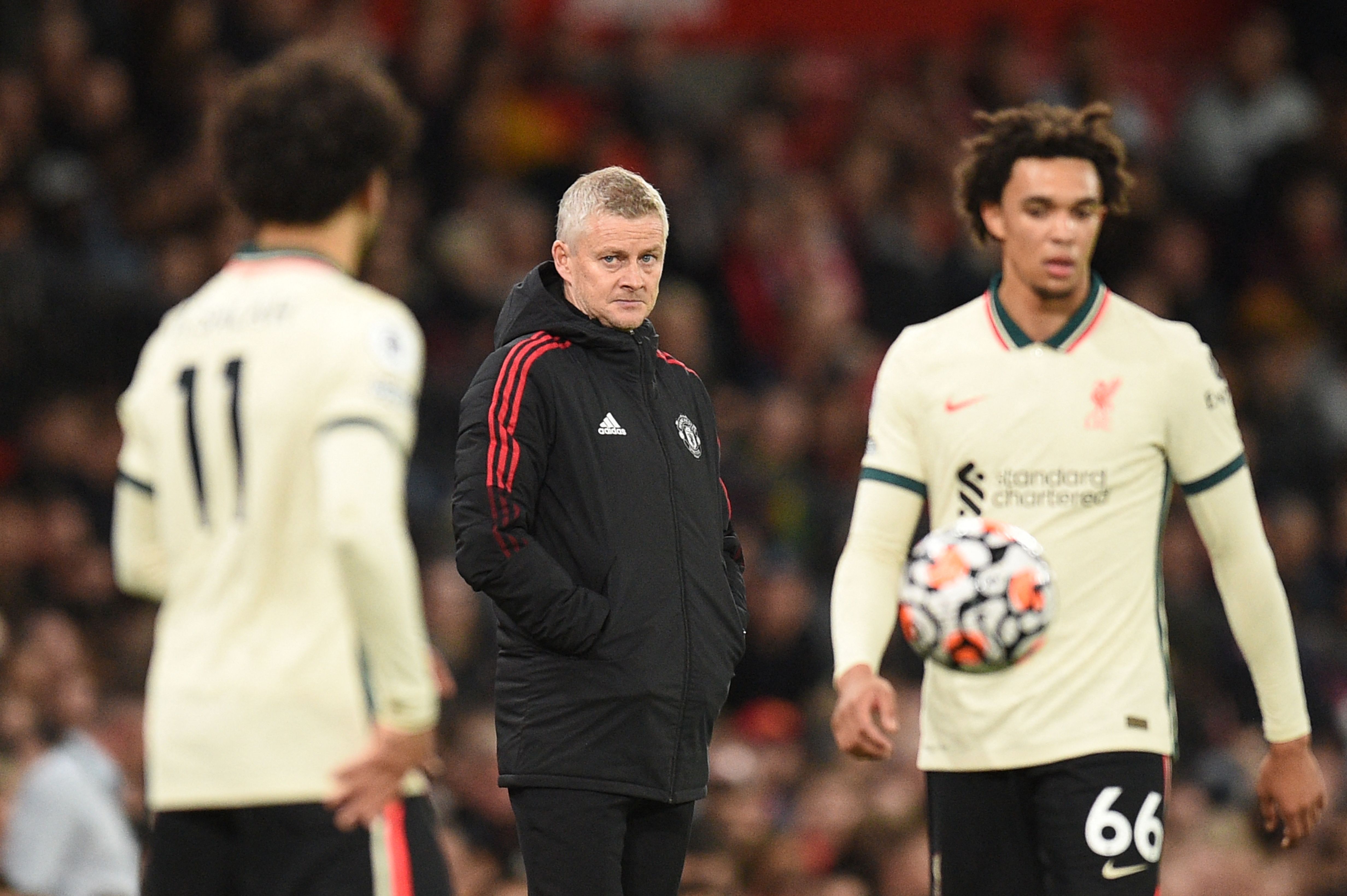 El entrenador noruego del Manchester United Ole Gunnar Solskjaer contempla desde lejos a sus rivales del Liverpool, Mohammed Salah (izquierda) y Trent Alexander Arnold. (Foto Prensa Libre: AFP)