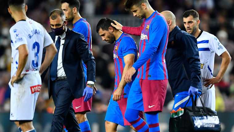 El jugador del Barcelona Gerard Pique (centro derecha) consuela a su compañero Kun Aguero mientras este abandona la cancha en el duelo ante el Deportivo Alaves este 30 de octubre en el Camp Nou. (Foto Prensa Libre: AFP)