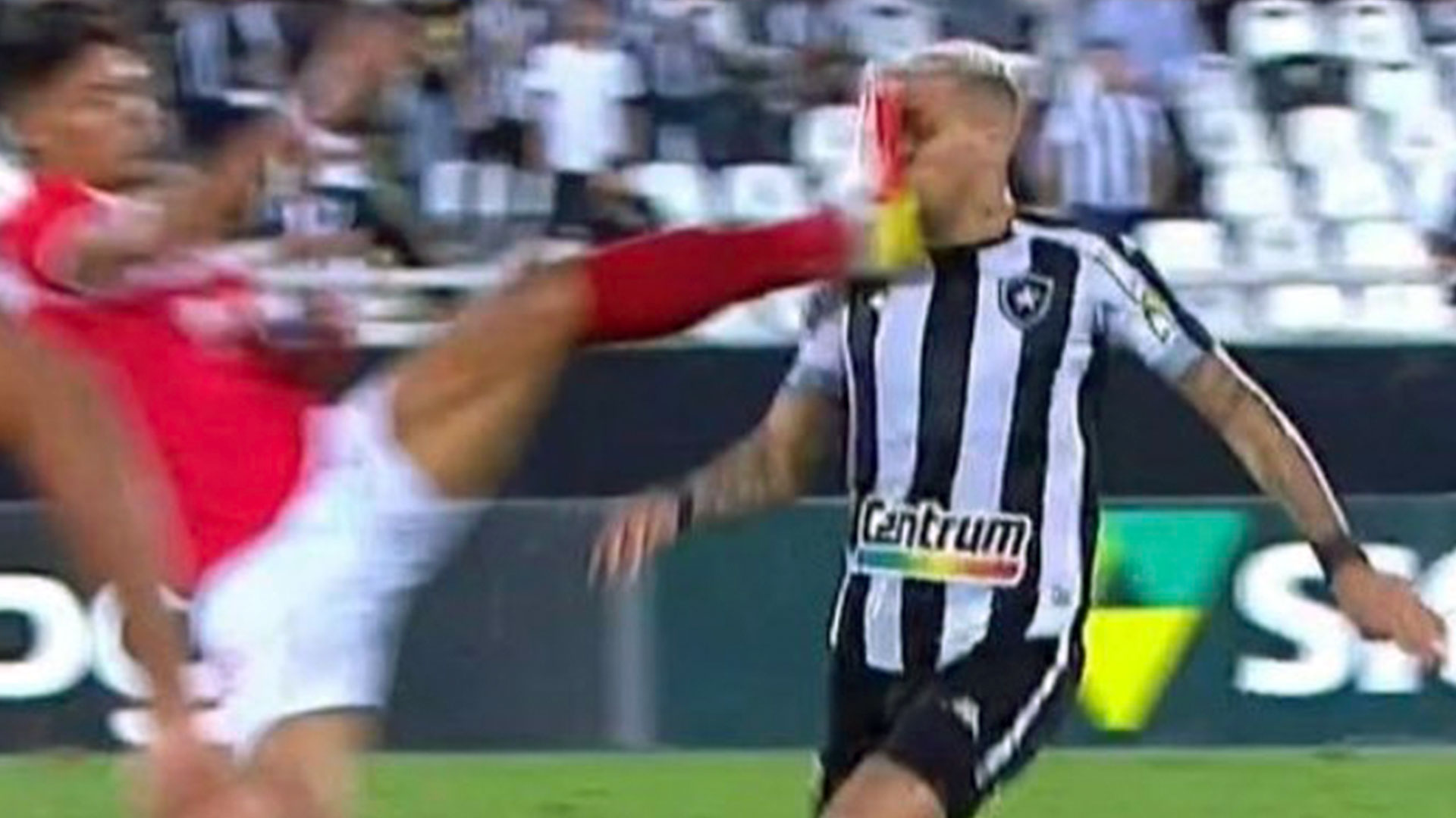 El momento exacto en el que el defensa del Clube de Regatas Brasil Joao Caetano (rojo) dejó sus tachones en el rostro del delantero del Botafogo Rafael Navarro. (Foto Prensa Libre: Twitter)