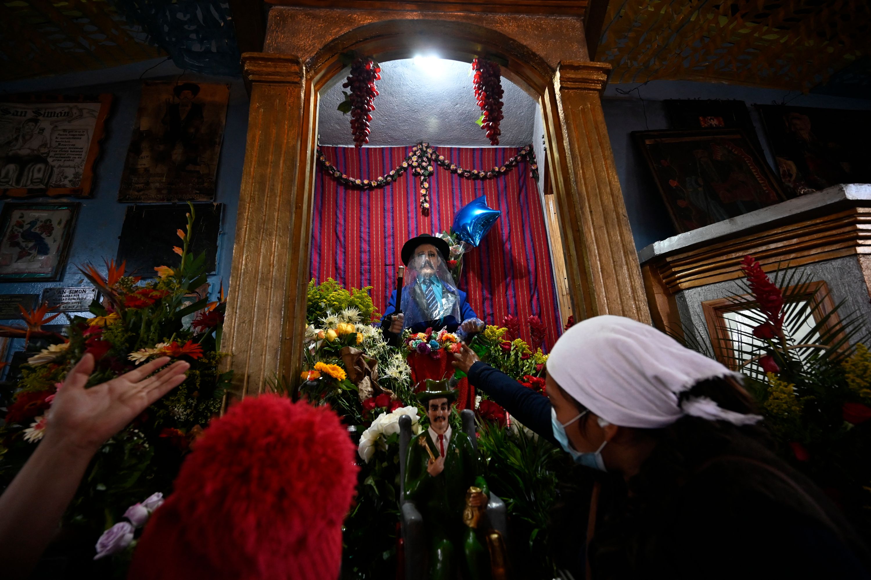 Cada 28 de octubre, decenas de creyentes celebran a San Simón, cuyo templo se sitúa en San Andrés Itzapa, Chimaltenango. (Foto Prensa Libre: AFP)