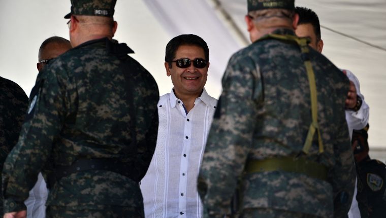 (FILES) In this file photo taken on October 19, 2019, Honduran President Juan Orlando Hernandez (C) attends a parade commemorating the Army Day in Tegucigalpa. - President of Honduras since 2014 and re-elected until 2022 with the blessing of the United States, Juan Orlando Hernandez is now accused of being a drug trafficker by his own ally, although he remains shielded by his parliamentary majority. (Photo by ORLANDO SIERRA / AFP)
