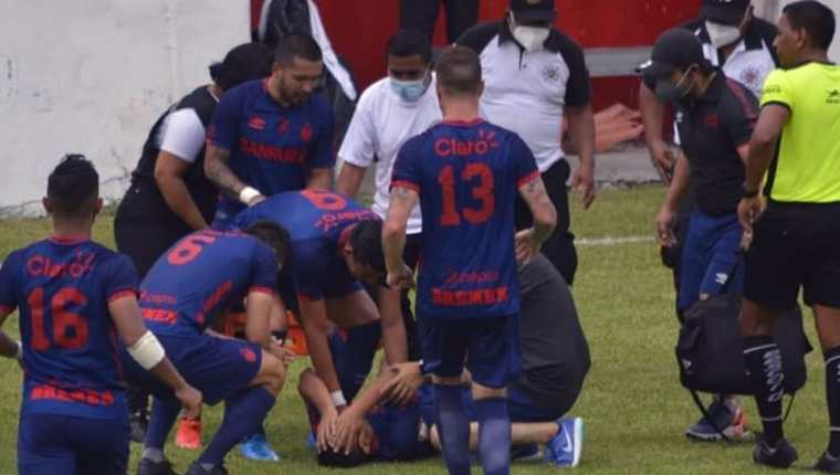 El futbolista de Municipal John Méndez recibe el apoyo de sus compañeros tras lesionarse en el duelo ante Iztapa. (Foto Prensa Libre: FutbolerosGT)