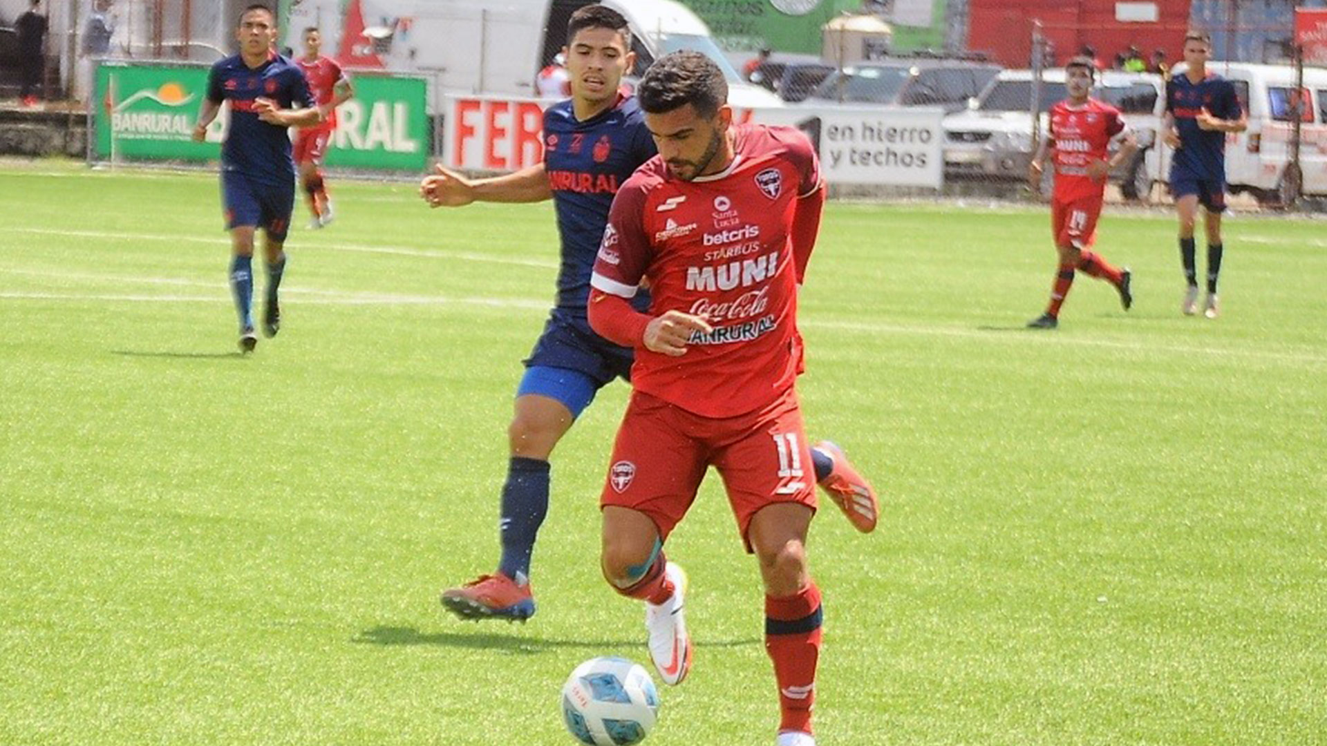El jugador de Malacateco Matías Rotondi (rojo) gana el balón ante la marca de un rival. (Foto Prensa Libre: Liga Nacional Facebook)