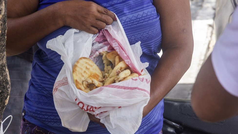 El desperdicio de unos es comida para otros. Una mujer muestra unos panes recién encontrados en un camión de basura. (JONAS RIO)