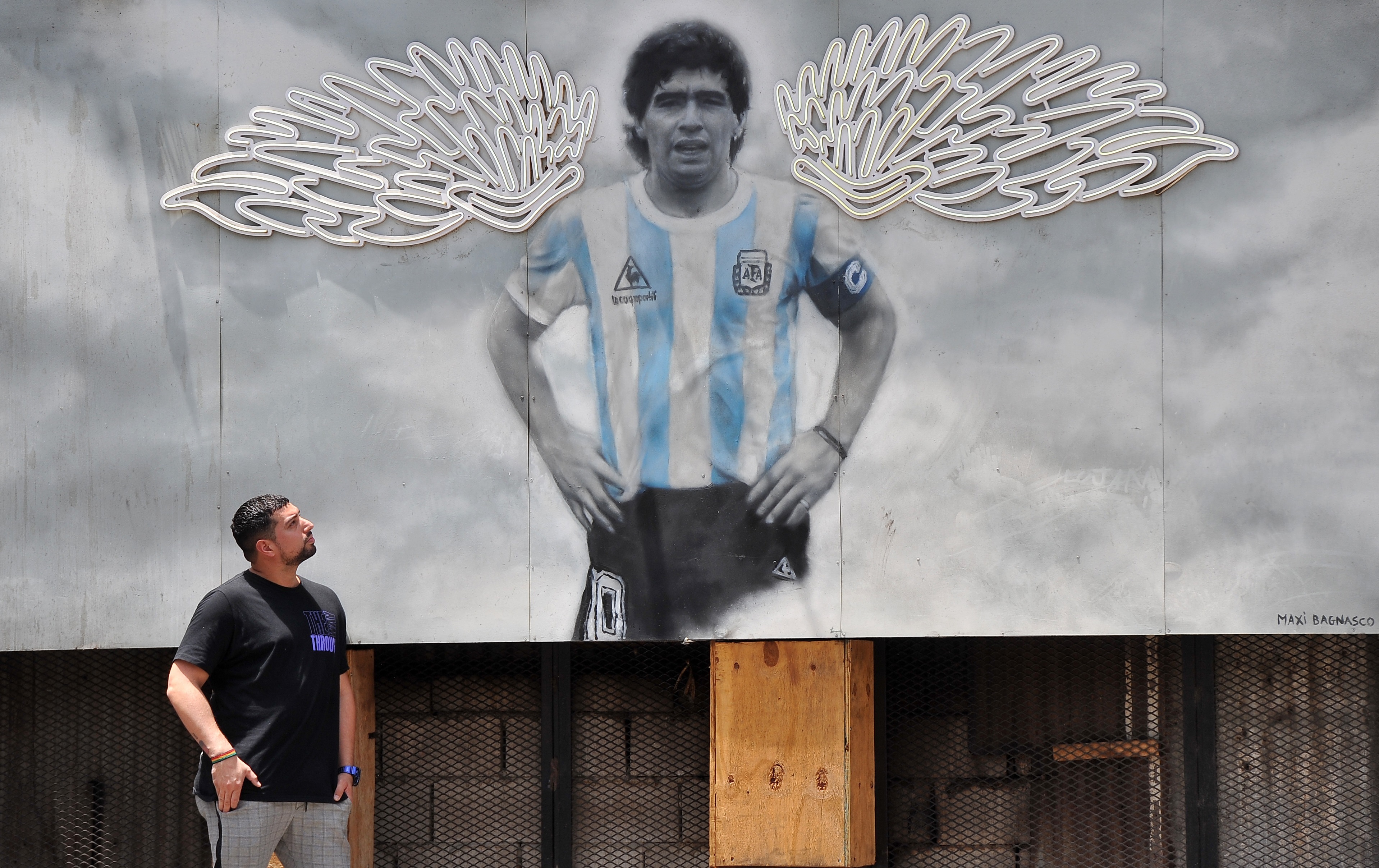 -FOTODELDÍA- AME313. BUENOS AIRES (ARGENTINA), 25/11/2021.- Un hombre camina frente a un mural con la imagen del astro del fútbol Diego Maradona en el barrio Chacarita, Buenos Aires (Argentina). El 25 de noviembre de 2020 el mundo se sacudió con la noticia de la muerte del astro del fútbol Diego Maradona, uno de los deportistas más famosos de todos los tiempos. A un año exacto de su muerte, la Justicia argentina todavía investiga qué pasó en los días y horas anteriores a su fallecimiento. EFE/ Enrique García Medina