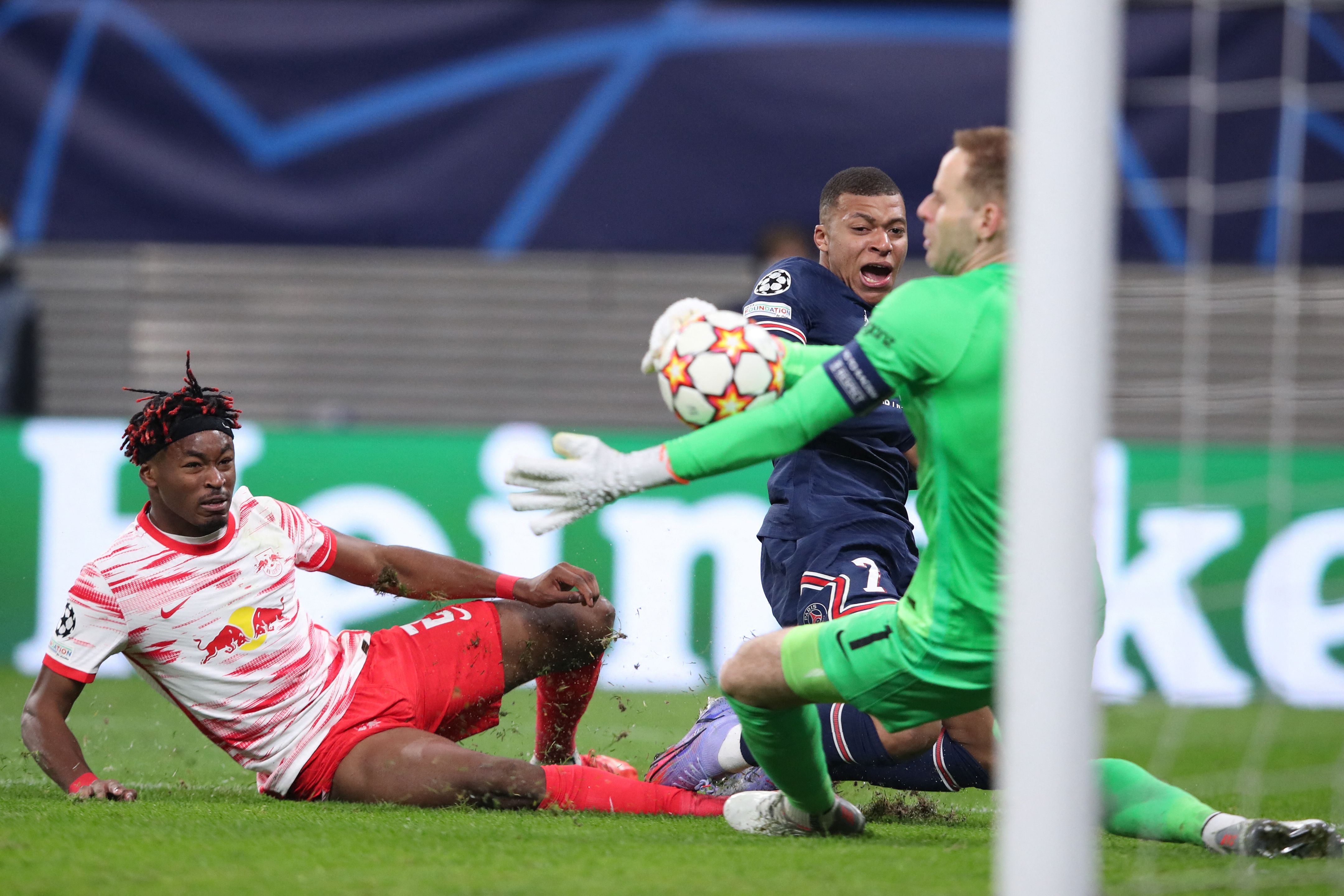 El delantero francés del PSG, Kylian Mbappe (C) patea en balón entre el defensa del Leipzig  Mohamed Simakan (I) y el portero húngaro Peter Gulacsi. Foto Prensa Libre: AFP.