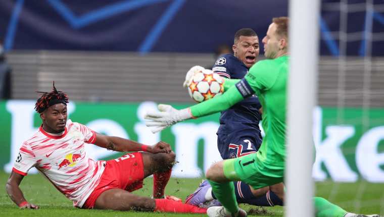 El delantero francés del PSG, Kylian Mbappe (C) patea en balón entre el defensa del Leipzig  Mohamed Simakan (I) y el portero húngaro Peter Gulacsi. Foto Prensa Libre: AFP.