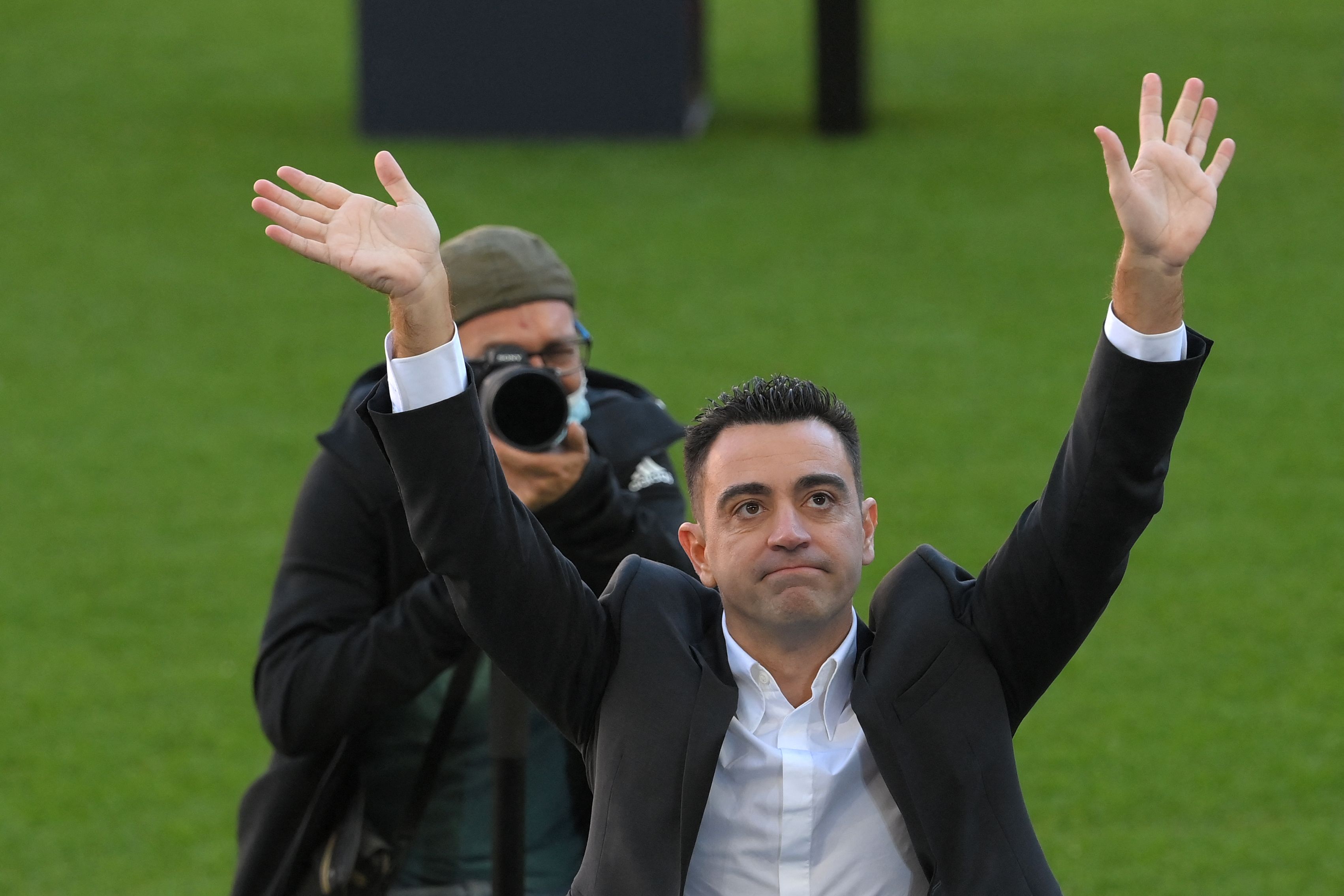 Xavi Hernández saluda a los aficionados que se hicieron presentes a su presentación como técnico del Barcelona. (Foto Prensa Libre: AFP).