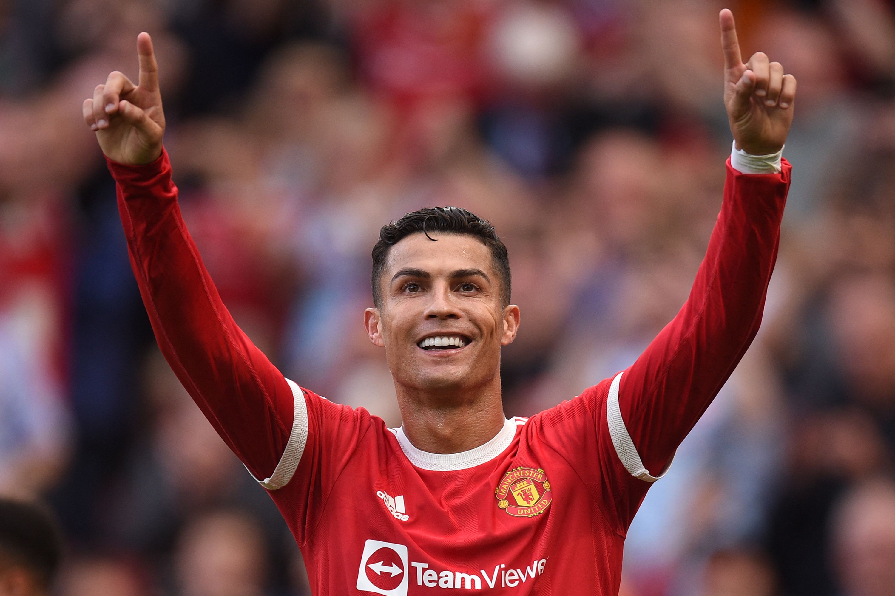(FILES) This file photo taken on September 11, 2021 shows Manchester United's Portuguese striker Cristiano Ronaldo celebrating after scoring their second goal during the English Premier League football match between Manchester United and Newcastle at Old Trafford in Manchester, north west England. - Lionel Messi appears to be the favourite to succeed himself and win a seventh Ballon d'Or on November 29, 2021 at the Theatre du Chatelet in Paris, where only Robert Lewandowski and Karim Benzema appear to be able to prevent this consecration. (Photo by Oli SCARFF / AFP) / RESTRICTED TO EDITORIAL USE. No use with unauthorized audio, video, data, fixture lists, club/league logos or 'live' services. Online in-match use limited to 120 images. An additional 40 images may be used in extra time. No video emulation. Social media in-match use limited to 120 images. An additional 40 images may be used in extra time. No use in betting publications, games or single club/league/player publications. /