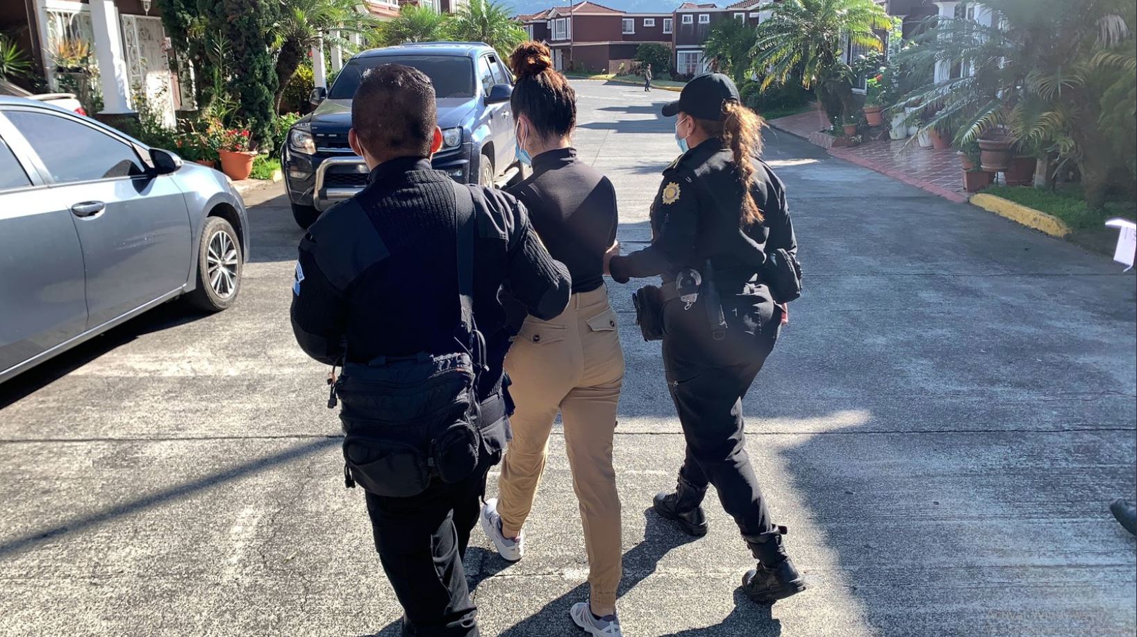 Varios trabajadores del Insivumeh fueron capturados durante 36 allanamientos. En la foto, agentes de la PNC traslada a Astrid Montes, de 23 años, detenida en Palín, Escuintla. (Foto Prensa Libre: PNC)