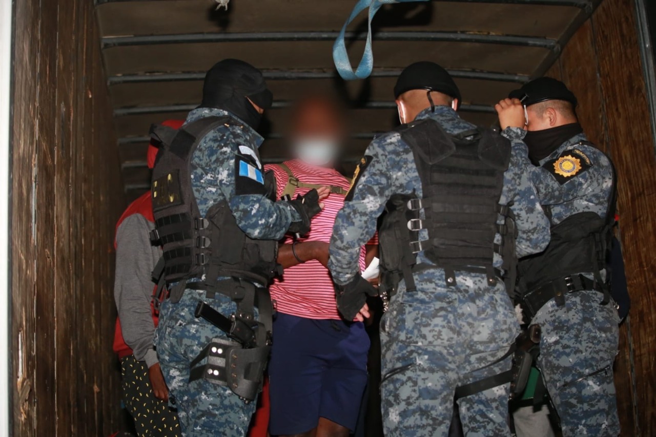 Agentes de la PNC trasladan a un grupo de migrantes haitianos que viajaban en un furgón de forma ilegal. (Foto Prensa Libre: PNC)