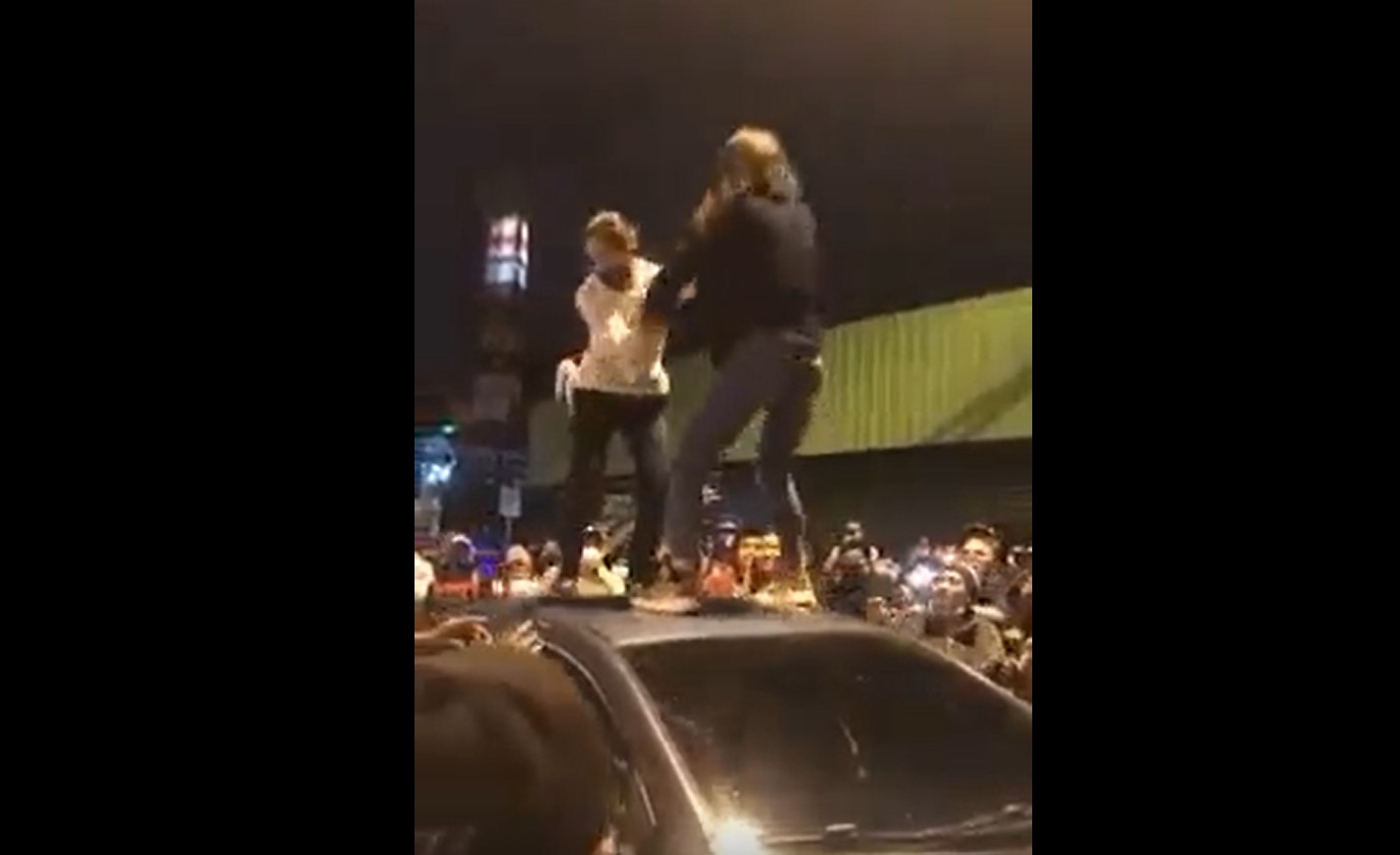 Una mujer protagonizó un escándalo frente a la Plaza el Amate en la zona 1, cuando se subió al techo de un vehículo. (Foto Prensa Libre: Captura de video)