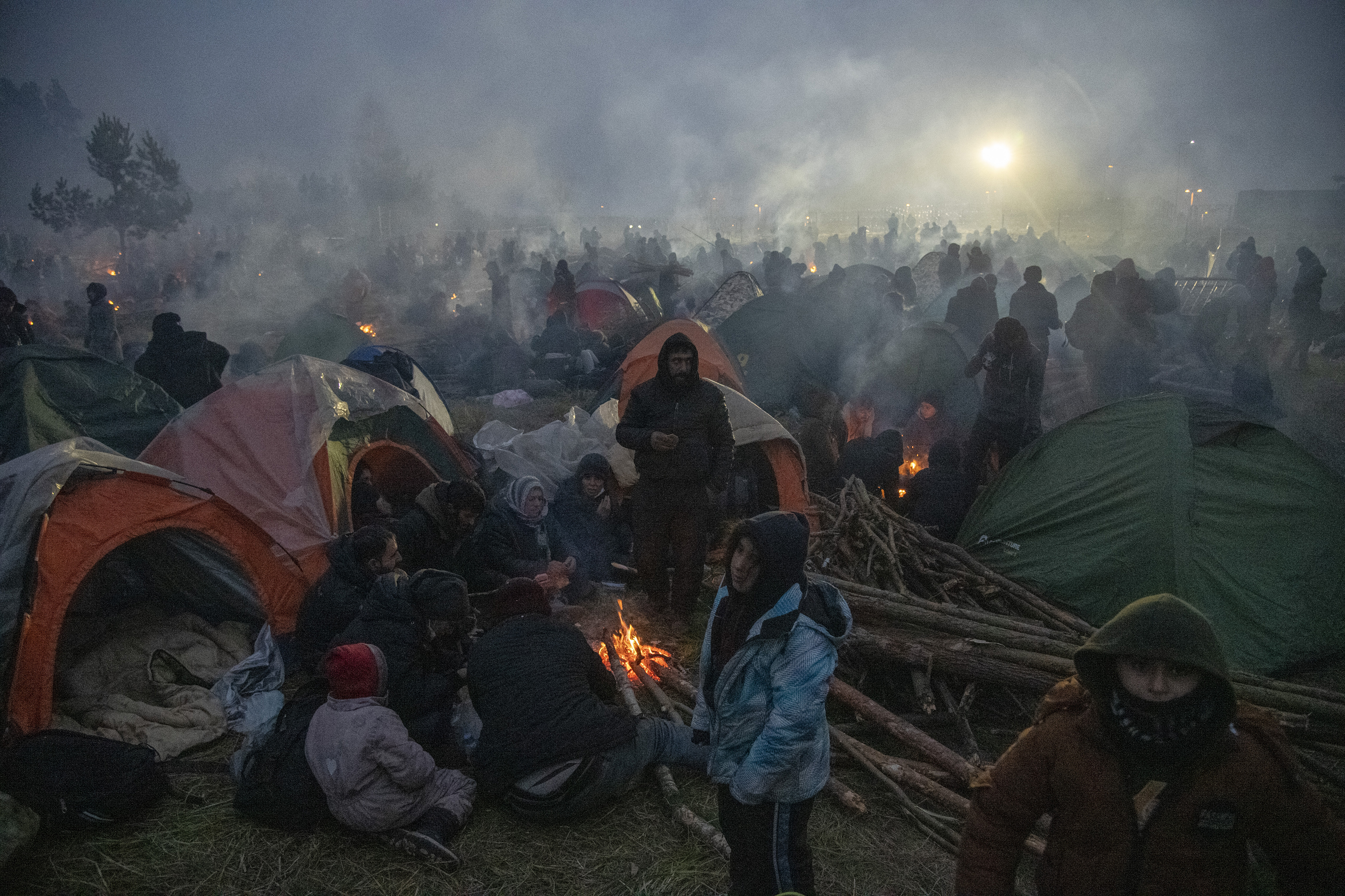 Los migrantes se reúnen alrededor de las fogatas mientras acampan para pasar la noche en la frontera con Polonia en Bielorrusia, el 16 de noviembre de 2021. Las imágenes en la frontera entre Bielorrusia y Polonia parecen familiares, pero esta emergencia tiene poco en común con oleadas anteriores de personas de Siria. Myanmar y Afganistán. (Foto Prensa Libre: James Hill / The New York Times)