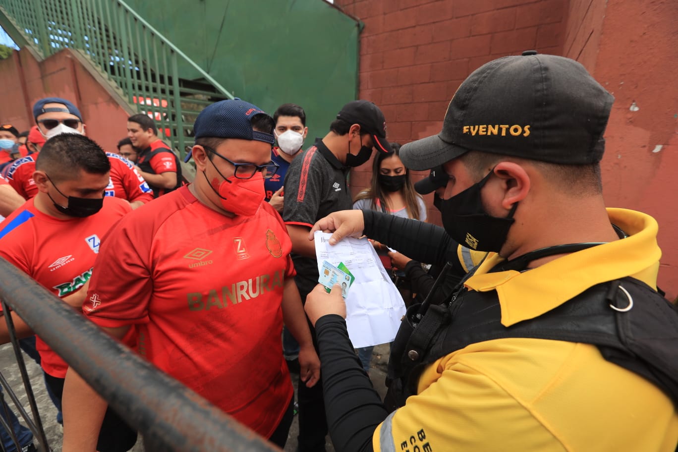 Los aficionados de Municipal presentando sus credeciales de vacunación en la entrada del estadio de Municipal. (Foto Prensa Libre: Byron García)