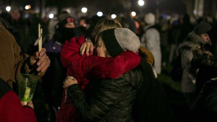 Personas se abrazan durante una vigilia en Waukesha, Wisconsin, por victimas de tragedia en desfile navideño. (Foto Prensa Libre: AFP) 