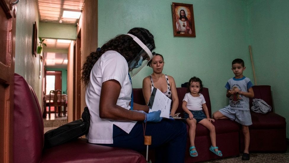 Una trabajadora del sector de la salud le daba información, en julio de 2020, a una familia sobre la prueba de detección de covid-19, en su hogar. (EZEQUIEL BECERRA/AFP VIA GETTY IMAGES)