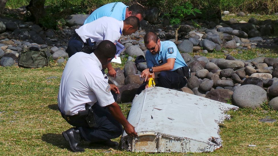 Oficiales de policía inspeccionan un resto del avión encontrado en la isla de La Reunión, en el Océano Índico. Reuters