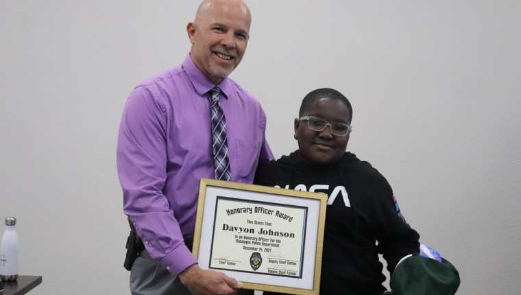 El jefe de policía de Muskogee, Johnny Teehee, otorgó un premio de oficial honorario a Davyon Johnson, de 11 años. Fotografía: BBC News.