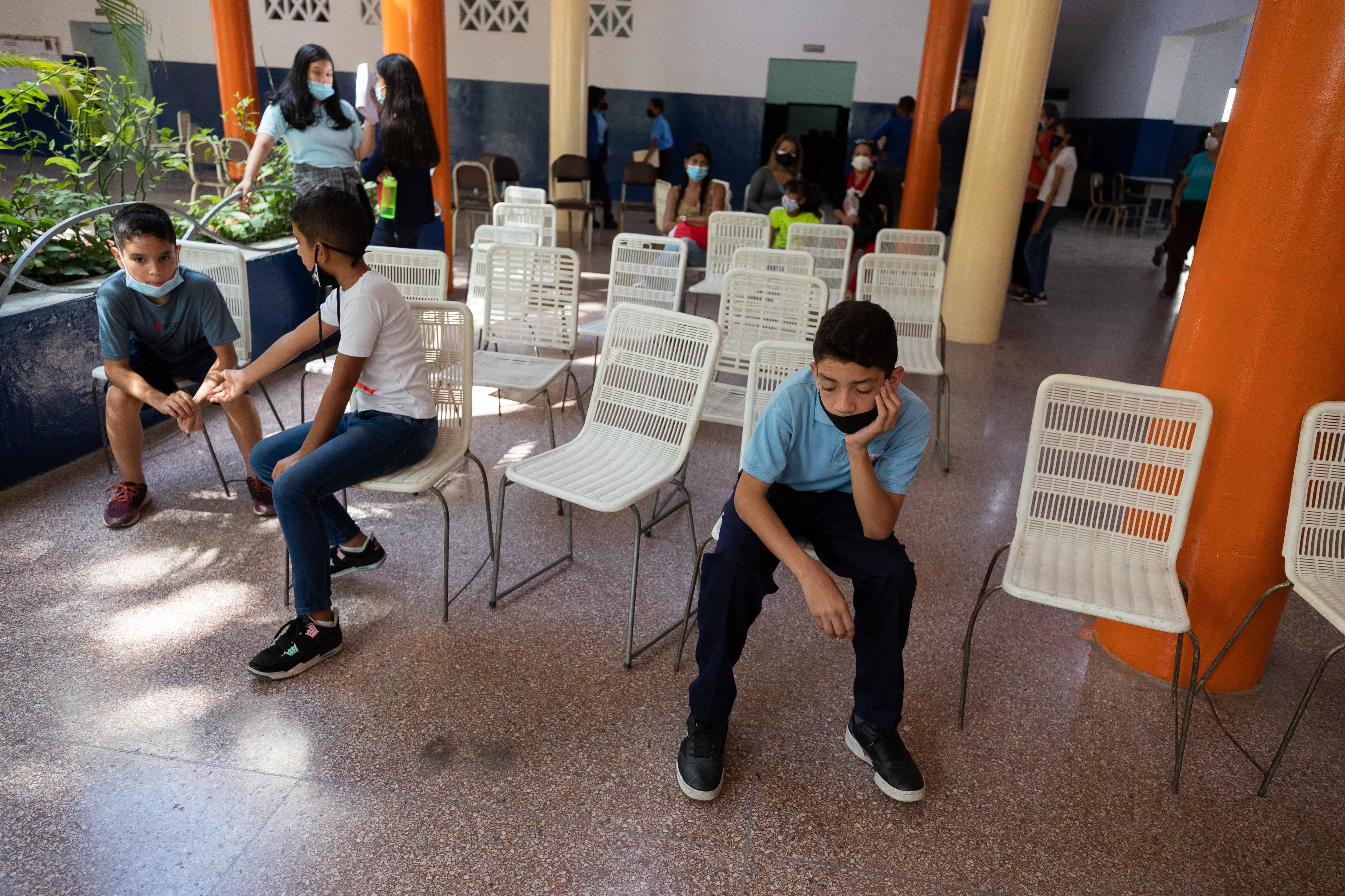 AME3859. CARACAS (VENEZUELA), 11/12/2021.- Niños esperan para obtener una dosis de la vacuna contra la covid-19 en un colegio, el 8 de diciembre de 202 en Caracas (Venezuela). Los centros de vacunación contra la covid-19 en Venezuela están vacíos ocho meses después de que se empezara a administrar el fármaco, un escenario que expertos atribuyen a la desconfianza en el sistema, mientras el Gobierno lo achaca a que el 80 % de la población ya fue inmunizada, frente al 34,3 % que computa la Organización Mundial de la Salud (OMS). EFE/ Rayner Peña