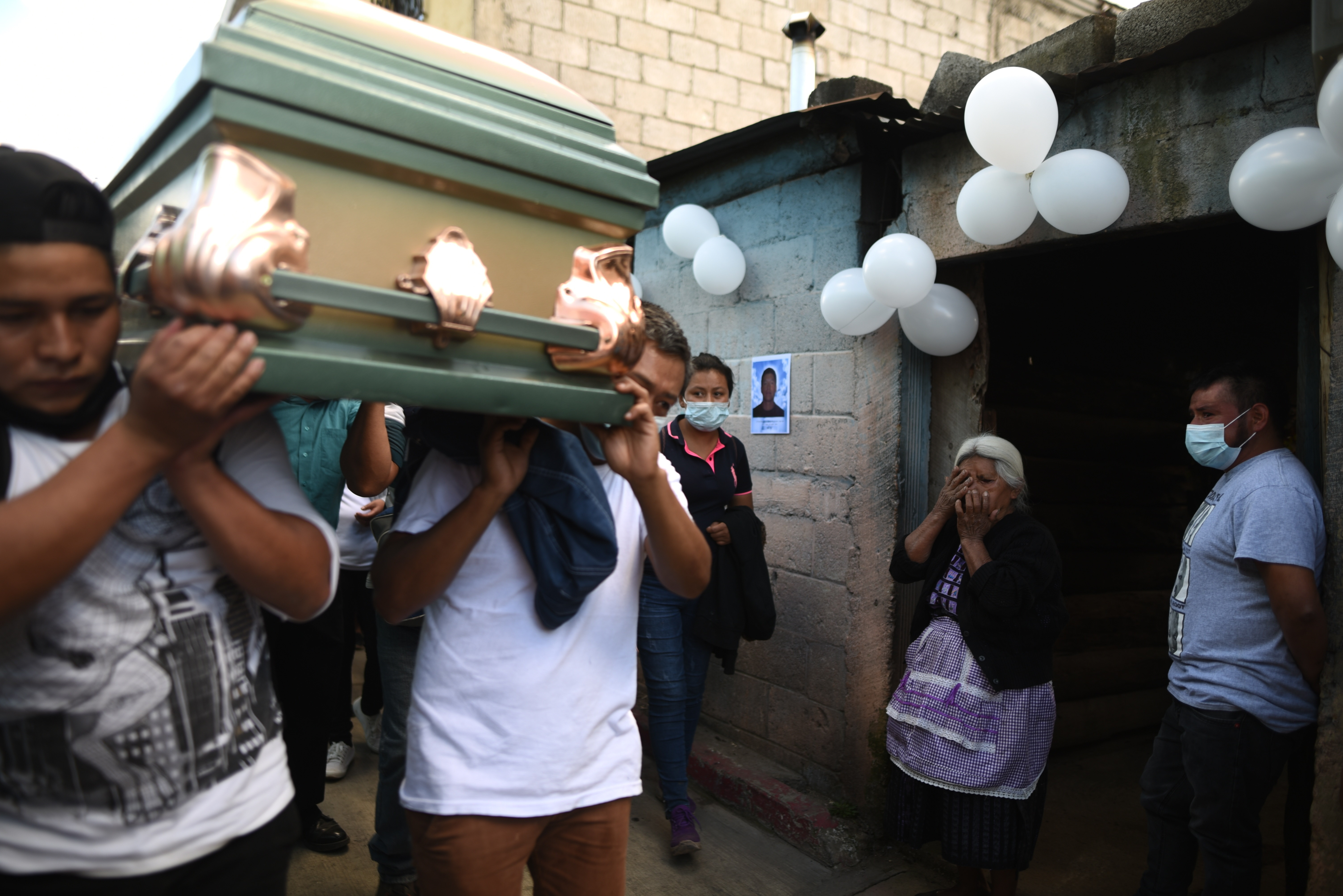 AME5438. CIUDAD DE GUATEMALA (GUATEMALA), 19/12/2021.- Familiares y amigos acompañan hoy en un cortejo fúnebre, el cuerpo de Daniel Arnulfo Pérez, uno de los cuatro migrantes fallecidos en el accidente de tránsito en Chiapas, México, que arribaron en la madrugada a la Fuerza Aérea Guatemalteca para su repatriación y posteriormente darle el ultimo adiós en el cementerio de El Tejar, Chimaltenango, a 50 kilómetros de la ciudad de Guatemala (Guatemala). Alrededor de medio centenar de personas velaron en este domingo en Guatemala los restos de Daniel Arnulfo Pérez, uno de los migrantes fallecidos el 9 de diciembre en un accidente de tránsito en México, donde otras 55 personas murieron y más de 100 resultaron lesionadas. EFE /Edwin Bercián