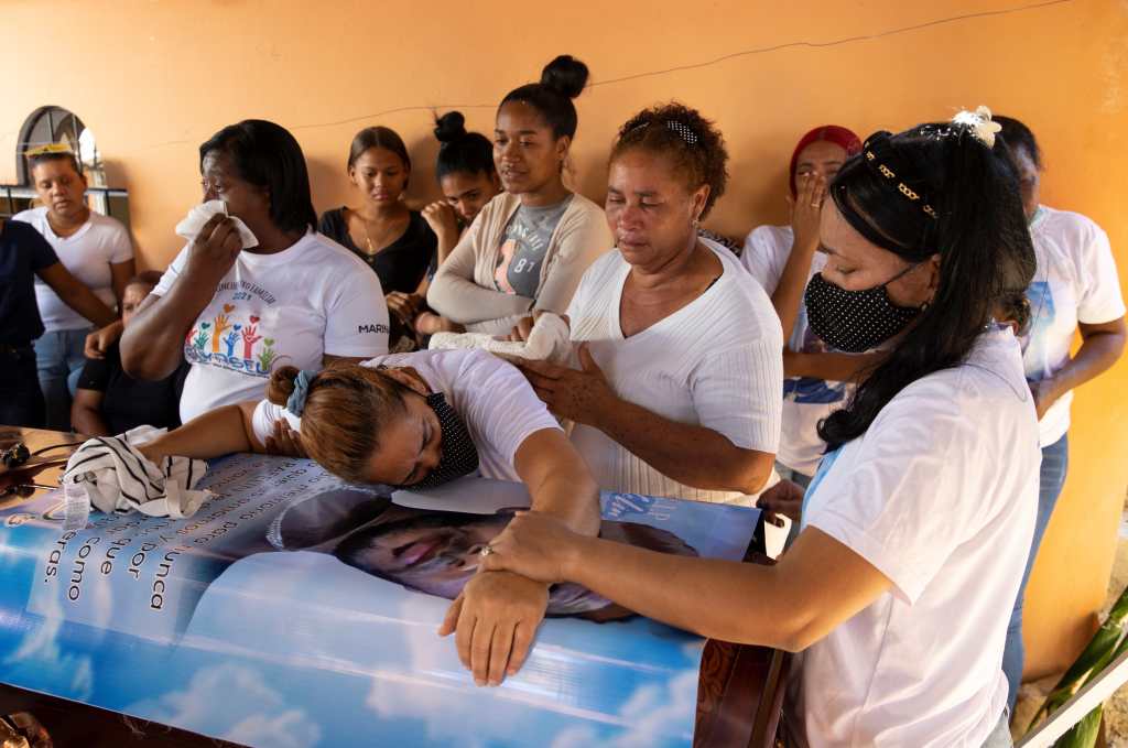 Kenia Castillo llora sobre el féretro donde está el cuerpo de su hijo Rafelín Martínez Castillo, uno de los migrantes dominicanos muertos en Chiapas. (Foto Prensa Libre: EFE)