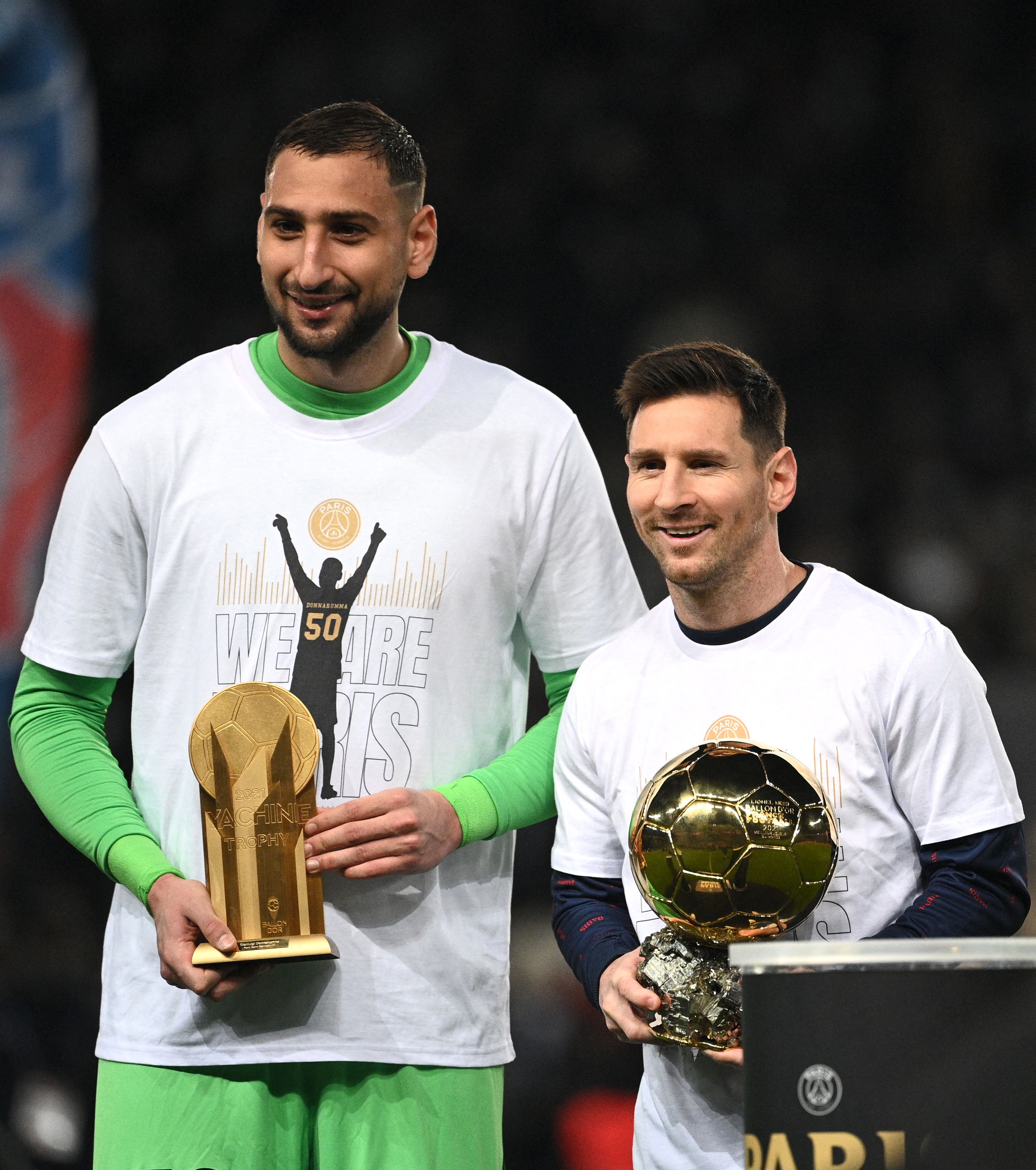 Paris Saint-Germain's Argentinian forward Lionel Messi pose with his men's Ballon d'Or award next to Paris Saint-Germain's Italian goalkeeper Gianluigi Donnarumma with the Yashin Trophy for best goalkeeper prior to the French L1 football match between Paris-Saint Germain (PSG) and OGC Nice at The Parc des Princes Stadium in Paris on December 1, 2021. (Photo by Anne-Christine POUJOULAT / AFP)
