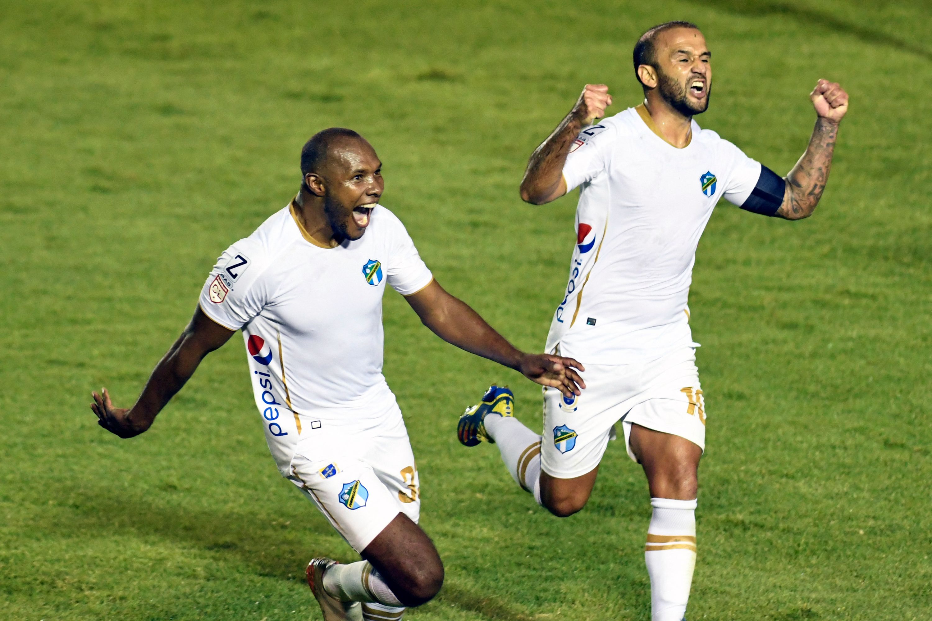 Guatemala's Comunicaciones Juan Anangono (L) celebrates after scoring against Honduras' Motagua during the Concacaf League football match final at Doroteo Guamuch stadium in Guatemala, City, on December 14, 2021. (Photo by Orlando ESTRADA / AFP)