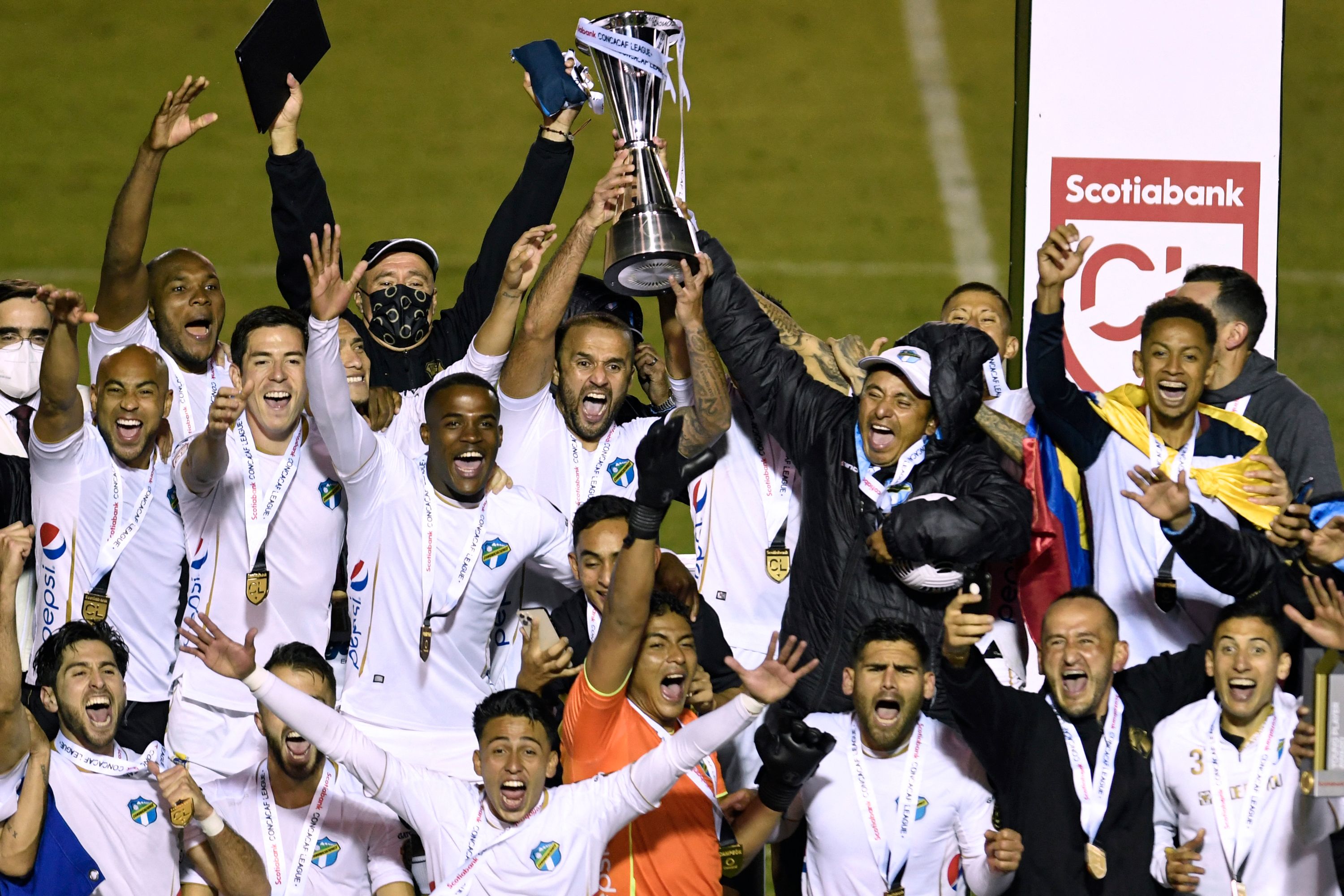 Los jugadores de Comunicaciones celebran con el trofeo después de ganar la la final de la Liga Concacaf ante el Motagua en el estadio nacional Doroteo Guamuch Flores. Foto Prensa Libre: AFP.