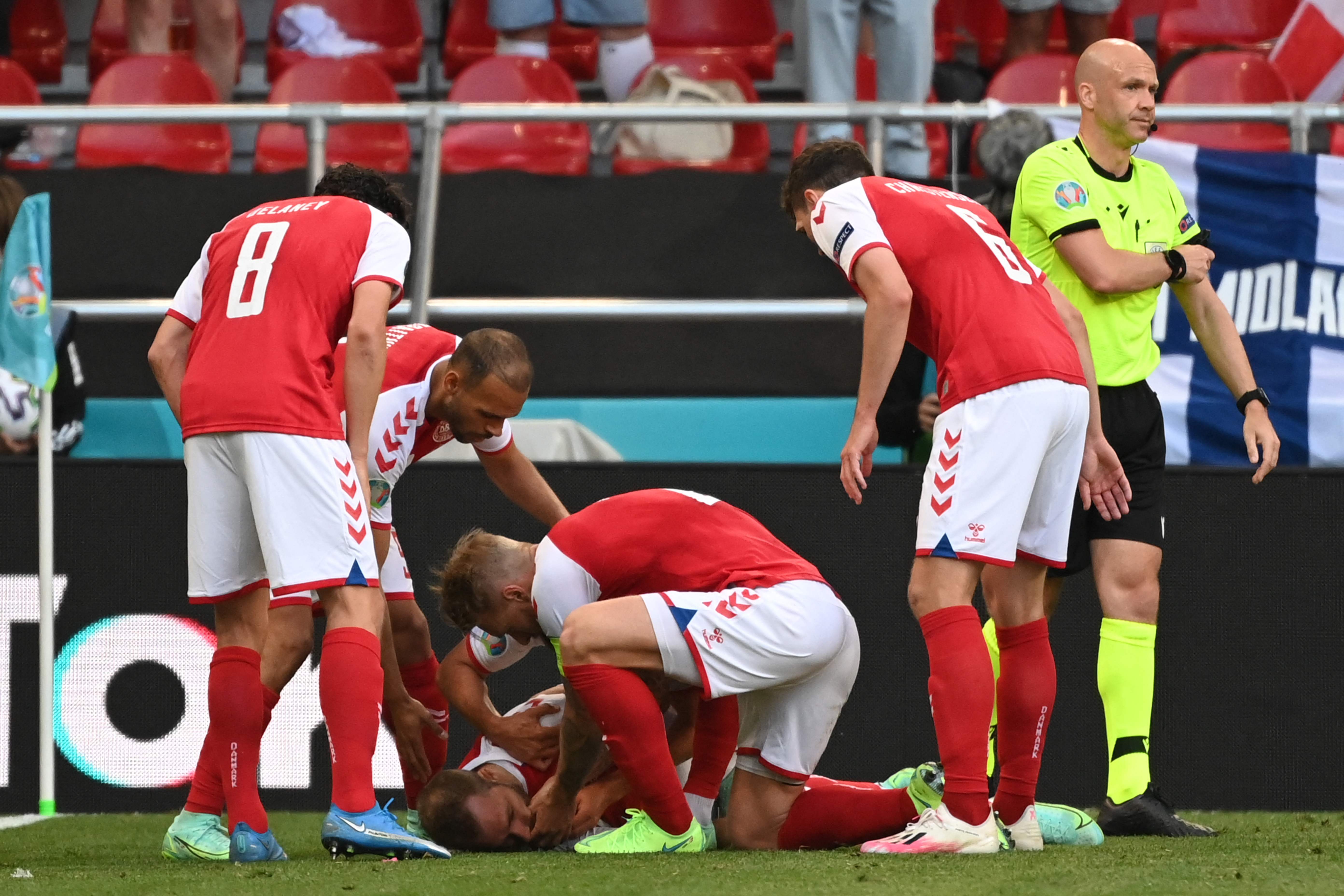 (FILES) In this file photo taken on June 12, 2021 Denmark players help Denmark's midfielder Christian Eriksen after he collapsed before the medics arrive during the UEFA EURO 2020 Group B football match between Denmark and Finland at the Parken Stadium in Copenhagen. - Six months after his collapse at the European Football Championship, Danish international Christian Eriksen has reached an agreement with his club Inter Milan to terminate his contract, the club said on December 17, 2021. (Photo by Jonathan NACKSTRAND / AFP)