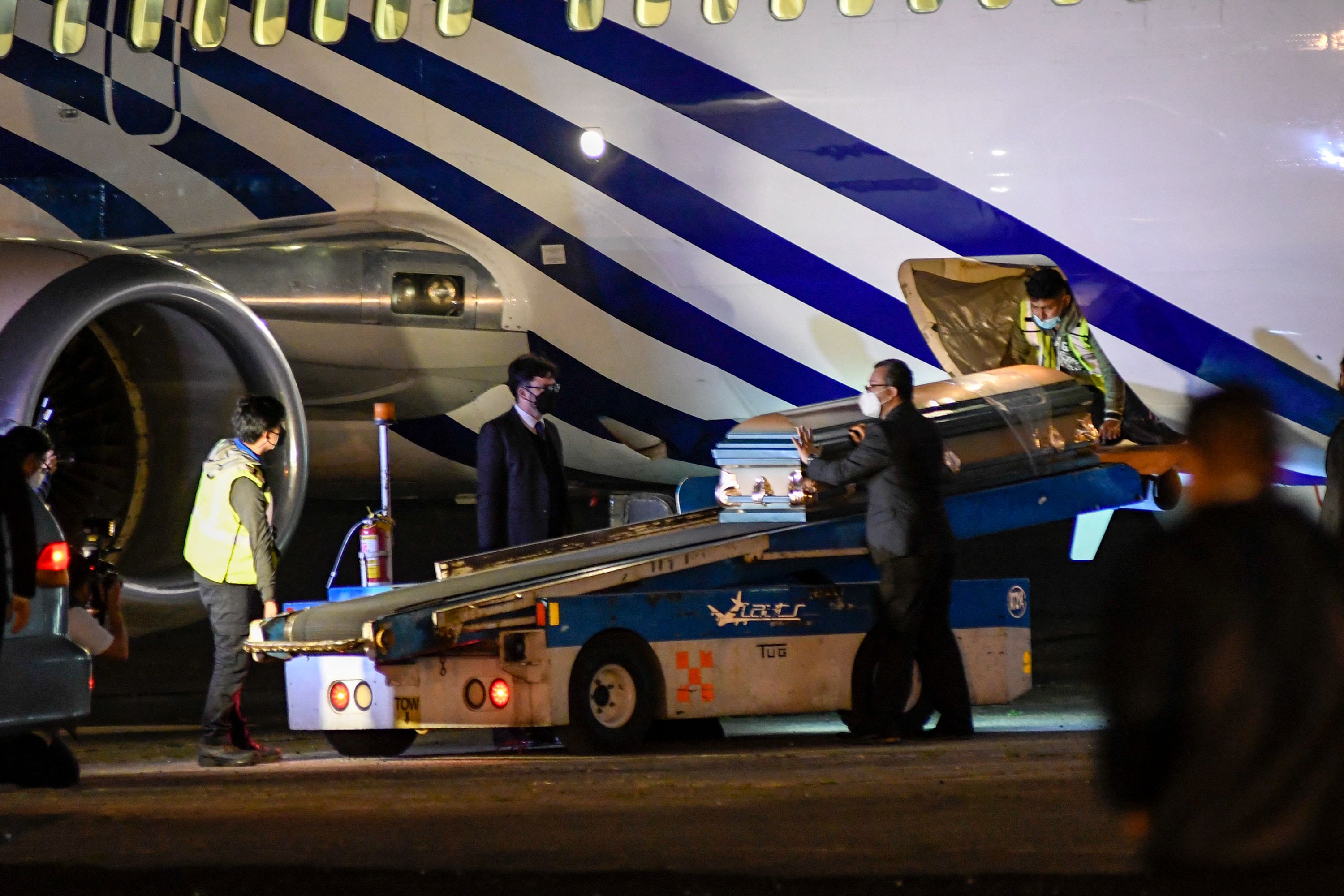 El avión que transportaba los cuerpos de los migrantes aterrizó en la Fuerza Aérea poco antes de las 23.30 horas. (Foto Prensa Libre: AFP)