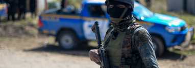 Un soldado vigila un área cercana a la aldea Chiquix, durante un operativo policial para dar con los responables de la masacre de 13 personas. (Foto Prensa Libre: AFP)