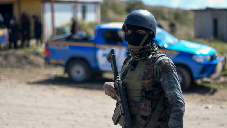 Un soldado vigila un área cercana a la aldea Chiquix, durante un operativo policial para dar con los responables de la masacre de 13 personas. (Foto Prensa Libre: AFP)