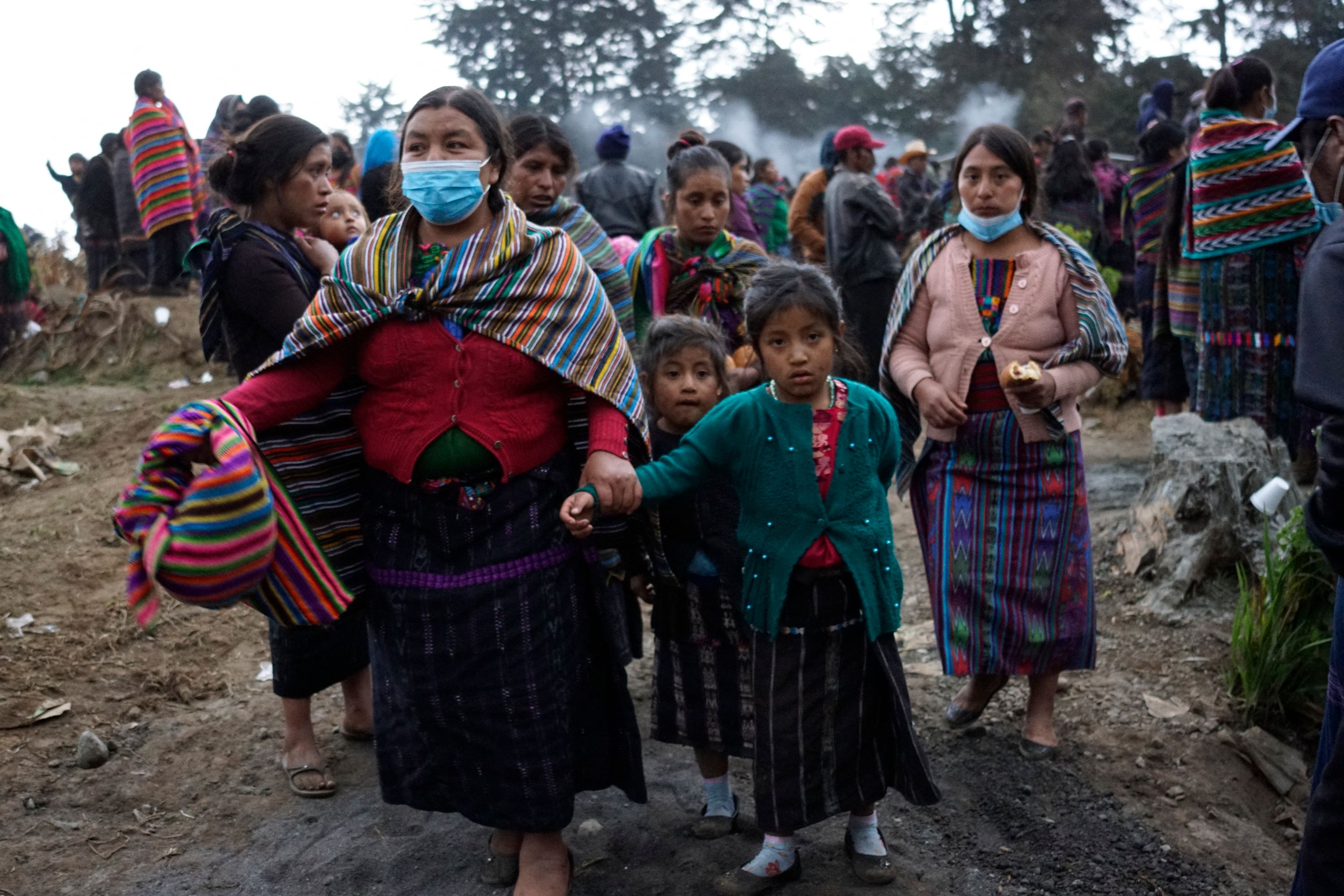 Indigenous people attend the burial of victims of a weekend massacre occurred in the nearby village of Chiquix, at the municipal cemetery of Chiquisis, in Santa Catarina Ixtahuacan municipality, Guatemala, on December 20, 2021. - Thirteen people, including four children were killed in the attack, part of a long-running land feud between members of the Mayan K'iche community from the neighbouring municipalities of Nahuala and Santa Catarina Ixtahaucan. (Photo by Johan ORDONEZ / AFP)