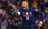 (FILES) In this file photo taken on November 13, 2021 France's forward Kylian Mbappe celebrates after scoring a goal during the FIFA World Cup 2022 qualification football match between France and Kazakhstan  at the Parc des Princes stadium in Paris. - Want-away striker Kylian Mbappe said December 28, 2021, he would finish the current season with Paris Saint-Germain, at which time he becomes a free agent. The brilliant 23-year-old striker was asked if he would be joining Real Madrid any time soon in an interview with CNN, and he had a sharp response. "Not in January," said Mbappe, who Madrid tried to buy in July with an audacious bid of 180 million euros ($209 million). (Photo by FRANCK FIFE / AFP)