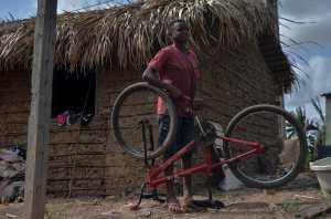 Gabriel Silva plays with a bicycle outside his house in Pinheiros, Maranhao state, Brazil, on December 10, 2021. - An illegal garbage dump seems an unlikely setting for a holiday story, but when a photojournalist captured 12-year-old Gabriel Silva pulling a Christmas tree from a fetid mountain of trash, the image quickly went viral. (Photo by JOAO PAULO GUIMARAES / AFP)
