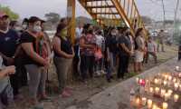 Varias personas colocan veladoras en el lugar del accidente de un camión donde viajaban migrantes, en el municipio Chiapa de Corzo, estado de Chiapas, México. En el percance murieron 55 personas. (Foto Prensa Libre: EFE)