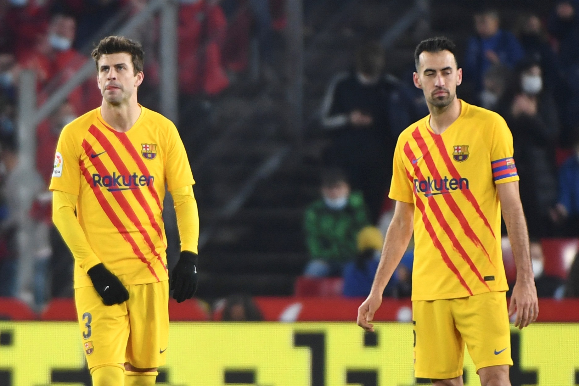 Los jugadores del FC Barcelona, Gerard Piqué (i) y Sergi Busquets, tras encajar el gol que ha significado el empate al Granada. (Foto Prensa Libre: EFE)