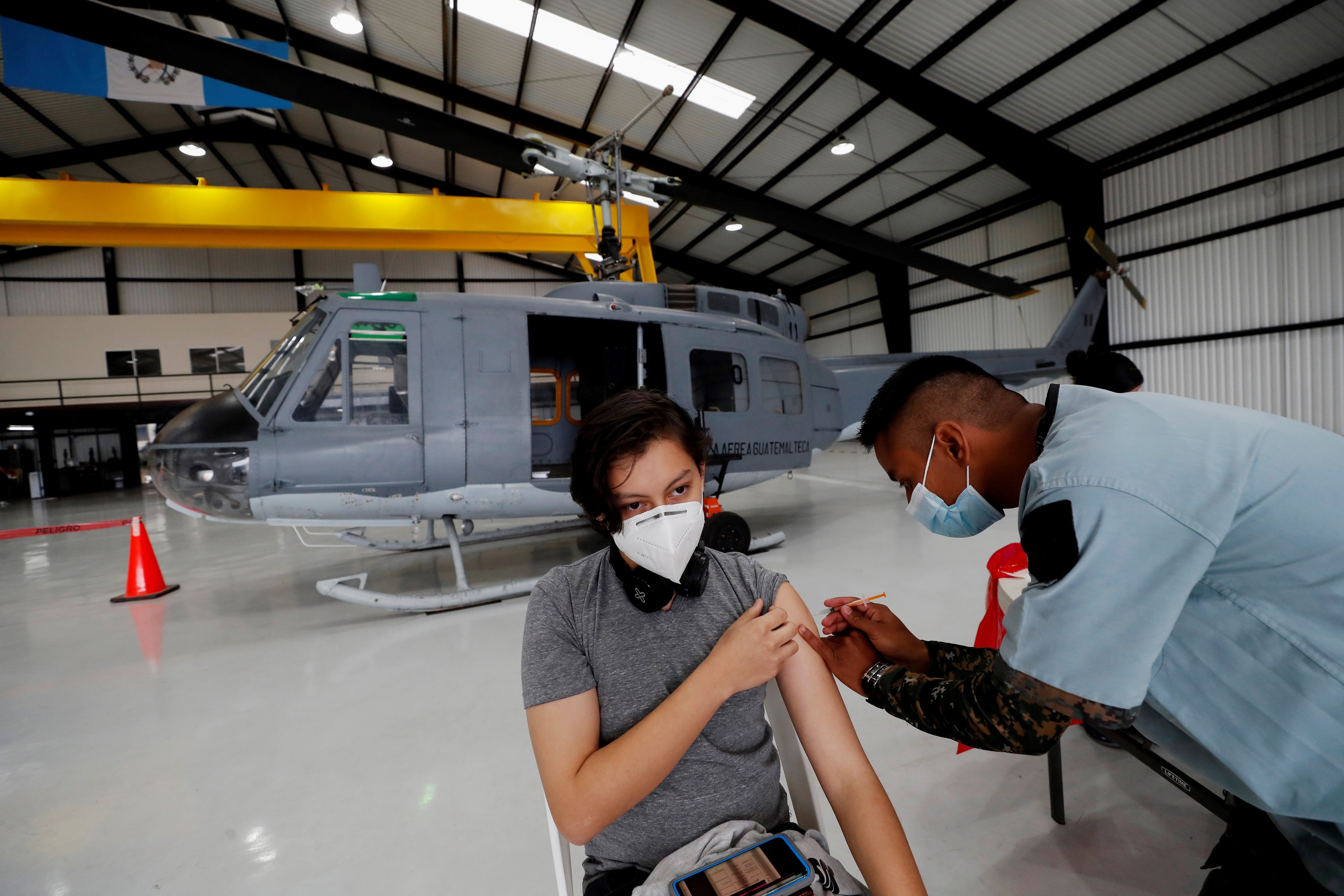 Una persona recibe una dosis de la vacuna contra la covid-19 durante una jornada de vacunación en la sede de la Fuerza Aérea, en Ciudad de Guatemala (Guatemala). Un hangar en la Fuerza Aérea Guatemalteca fue habilitado por el ejército para vacunar a la población guatemalteca con la motivación de hacerlo frente a las aeronaves de combate. EFE/ Esteban Biba