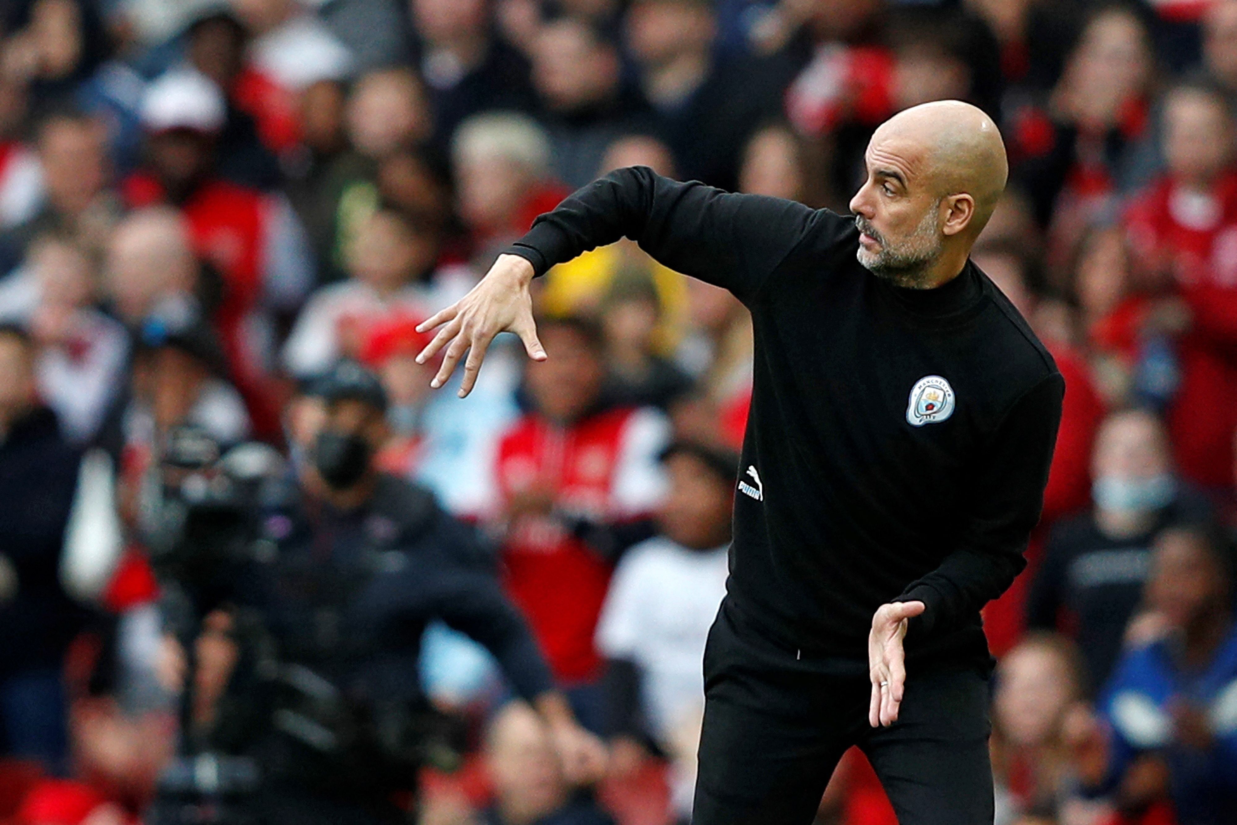 Manchester City's Spanish manager Pep Guardiola shouts instructions to his players from the touchline during the English Premier League football match between Arsenal and Manchester City at the Emirates Stadium in London on January 1, 2022. (Photo by Adrian DENNIS / AFP) / RESTRICTED TO EDITORIAL USE. No use with unauthorized audio, video, data, fixture lists, club/league logos or 'live' services. Online in-match use limited to 120 images. An additional 40 images may be used in extra time. No video emulation. Social media in-match use limited to 120 images. An additional 40 images may be used in extra time. No use in betting publications, games or single club/league/player publications. /