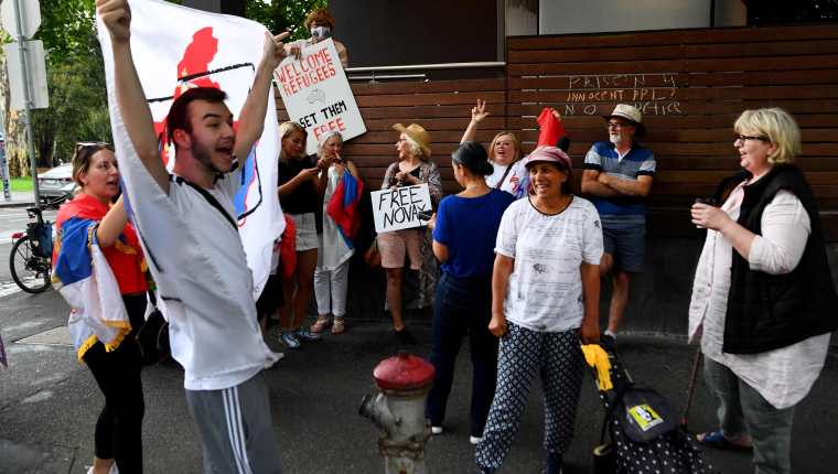 Miembros de la comunidad serbia en Australia se reunen afuera de un hotel donde el tenista se encuentra a la espera de su deportación. (Foto Prensa Libre: AFP)