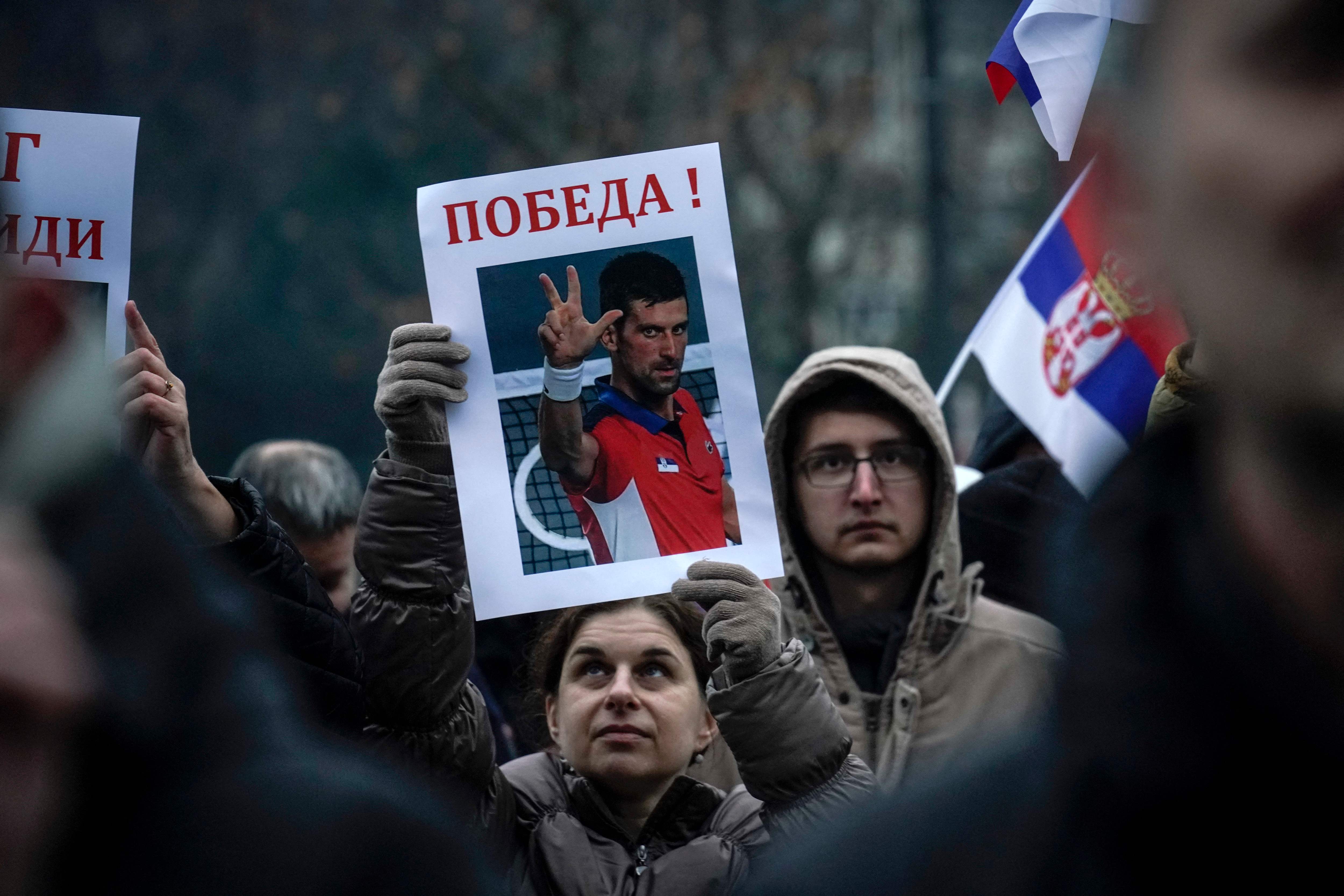 Una mujer sostiene una imagen de Novak Djokovic que dice "¡Victoria!", durante una concentración frente a la Asamblea Nacional de Serbia, en Belgrado. (Foto Prensa Libre: AFP)