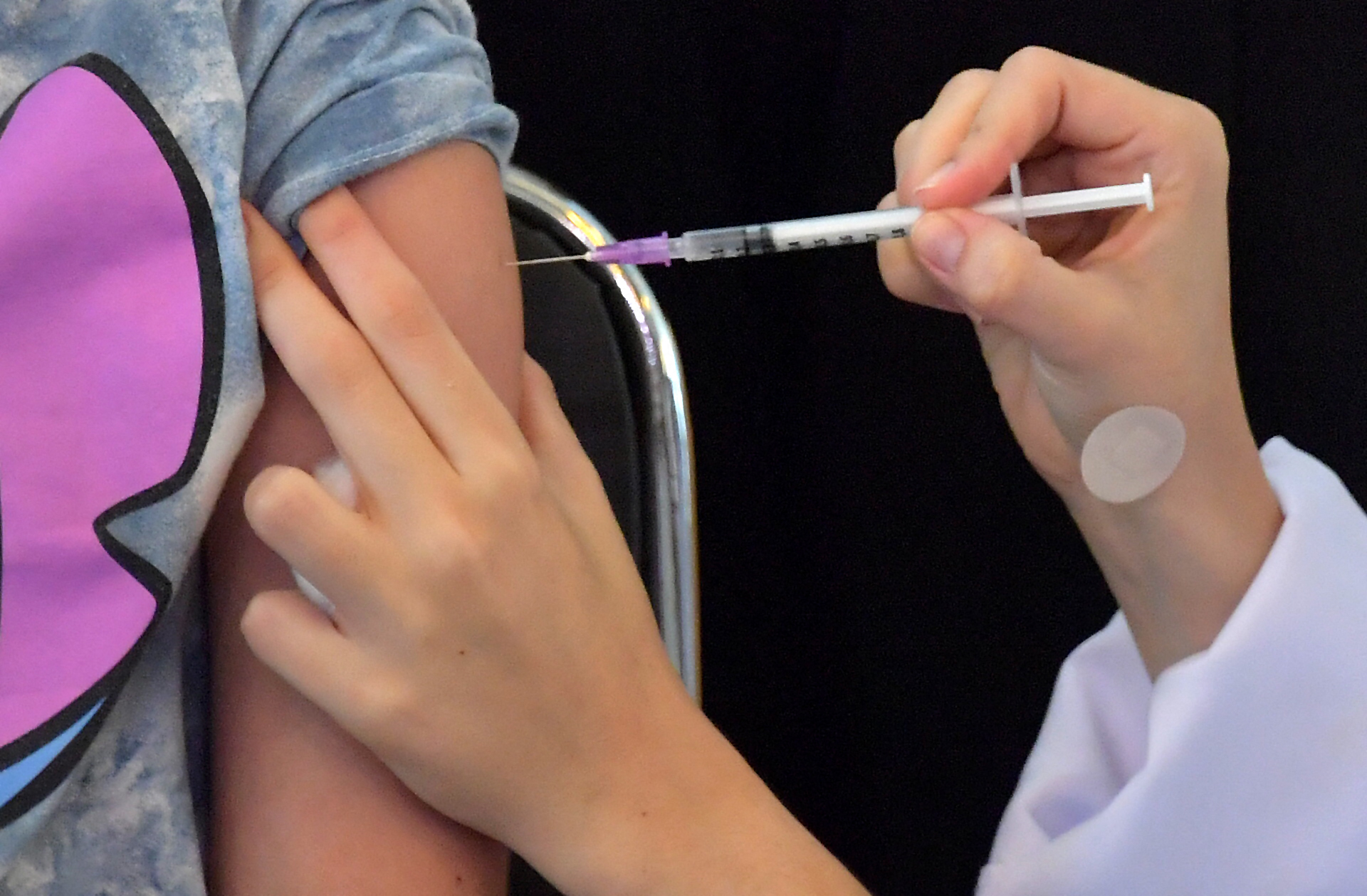 A girl receives the first dose of the Pfizer-BioNTech vaccine against COVID-19, at the Clinicas hospital in Sao Paulo, Brazil, on January 14, 2022. (Photo by NELSON ALMEIDA / AFP)