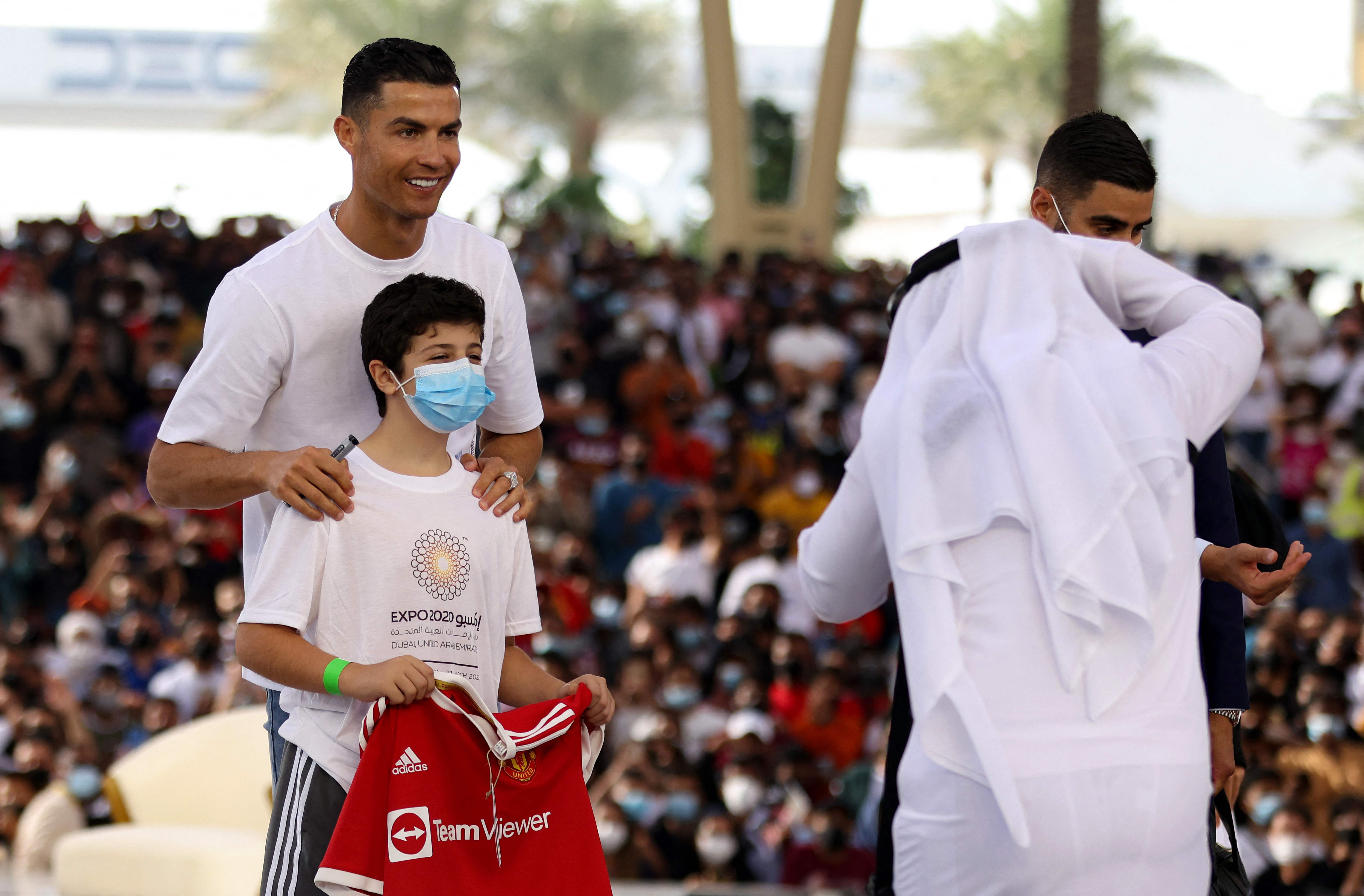 El delantero portugués del Manchester United, Cristiano Ronaldo posa con un niño en el al-Wasl Dome, durante su visita a la Expo 2020, en Dubai. Foto Prensa Libre: AFP.