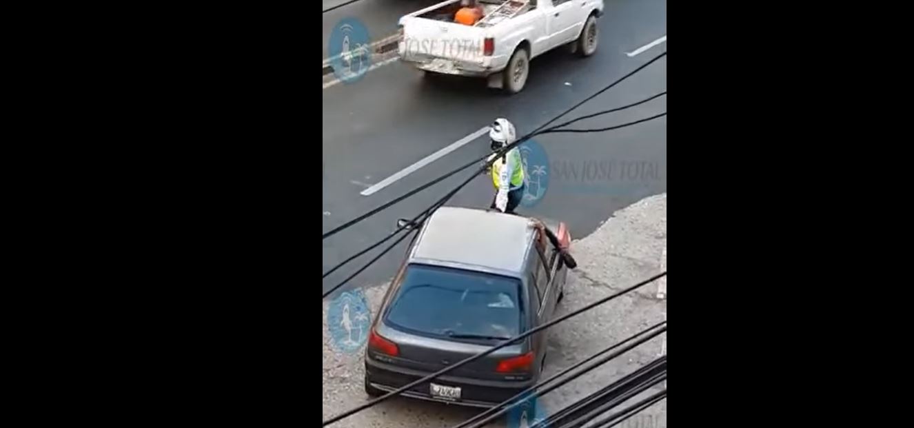 Un agente de la PMT fue llevado en el capó de un vehículo en un sector de la zona 4 de la capital. (Foto Prensa Libre: Captura de Pantalla)